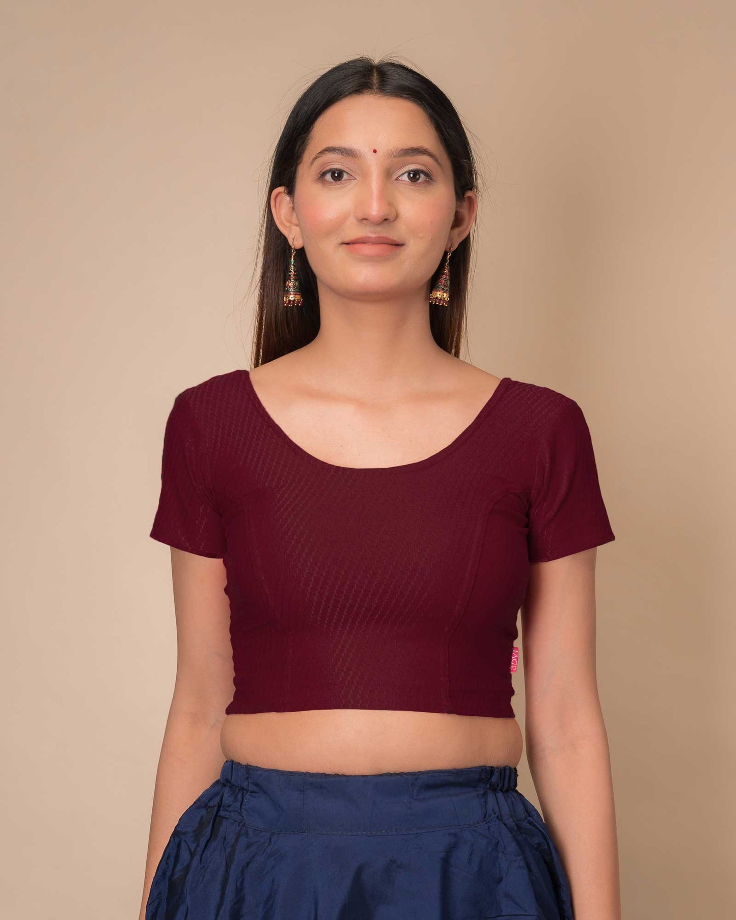 Model wearing a stretchable dobby cotton blouse with half sleeves and round neckline
