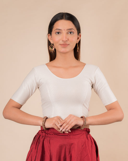Model wearing a dobby cotton stretchable blouse with elbow sleeves and round neckline