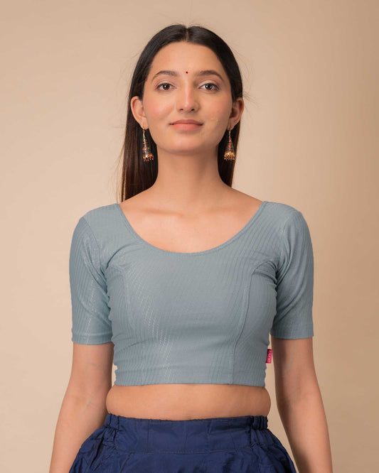 Model wearing a dobby cotton stretchable blouse with elbow sleeves and round neckline