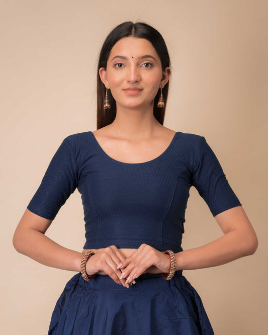 Model wearing a dobby cotton stretchable blouse with elbow sleeves and round neckline