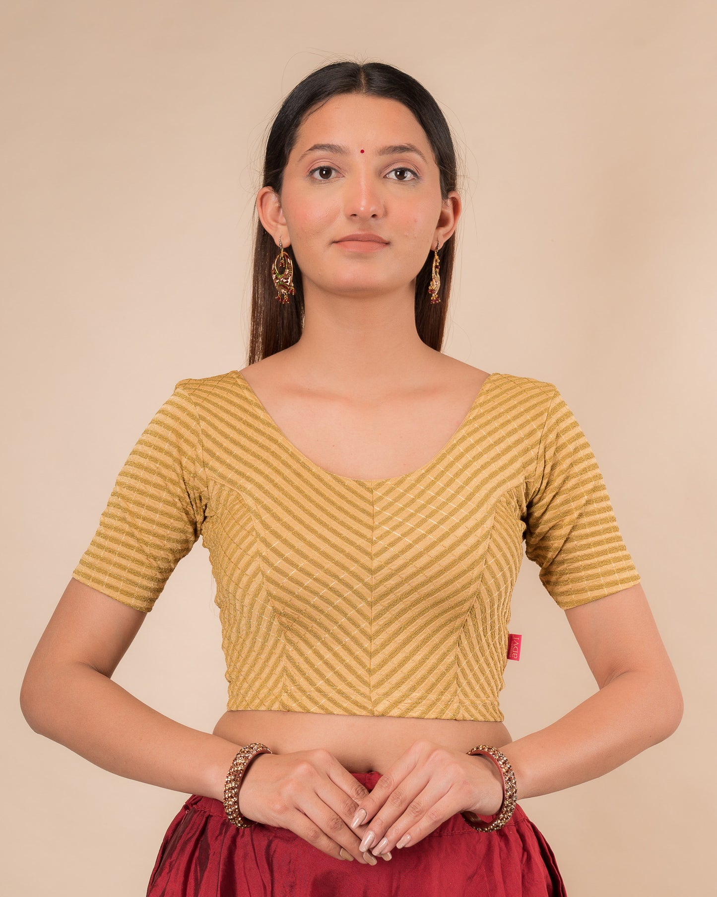 Model wearing a stretchable blouse with metallic zig‑zag stripes, elbow sleeves, and round neckline