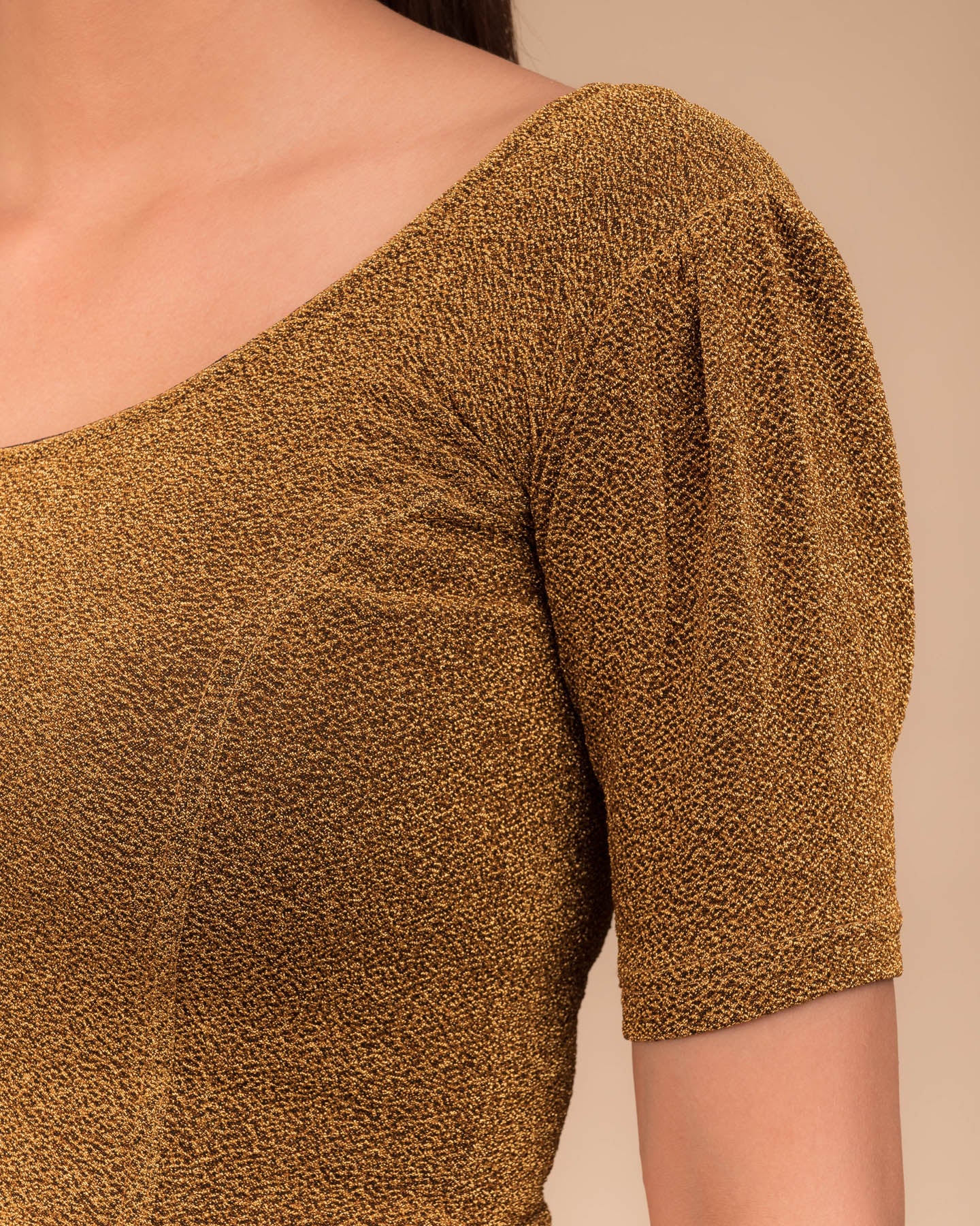 Close-up of the lurex fabric with fine pleating and subtle sheen