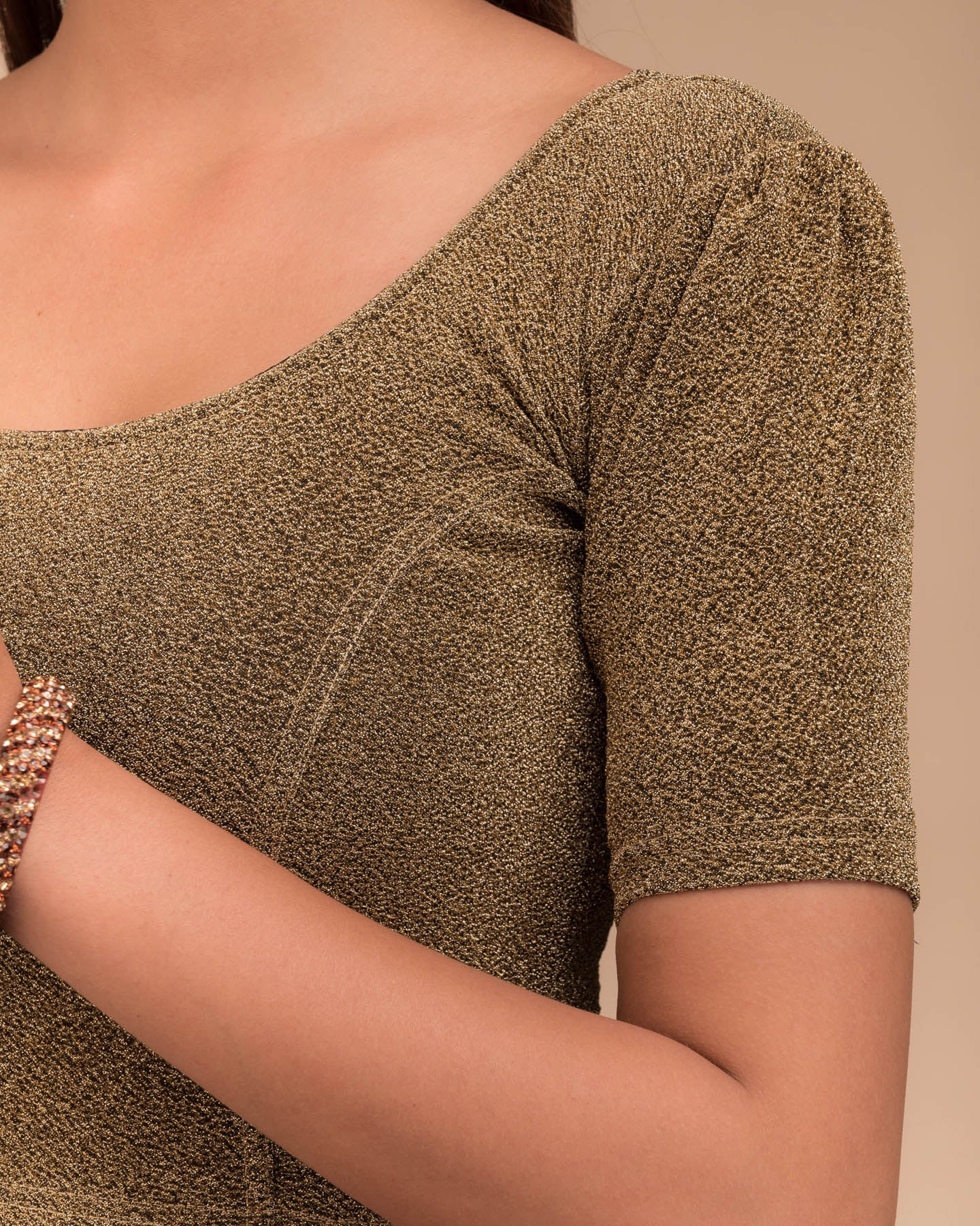 Close-up of the lurex fabric with fine pleating and subtle sheen