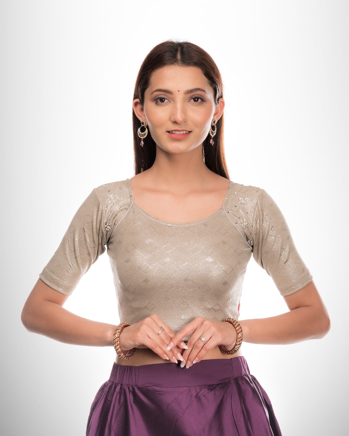 Model wearing a stretchable blouse with a sweetheart neckline and elbow sleeves, adorned with pearl and sequin details.