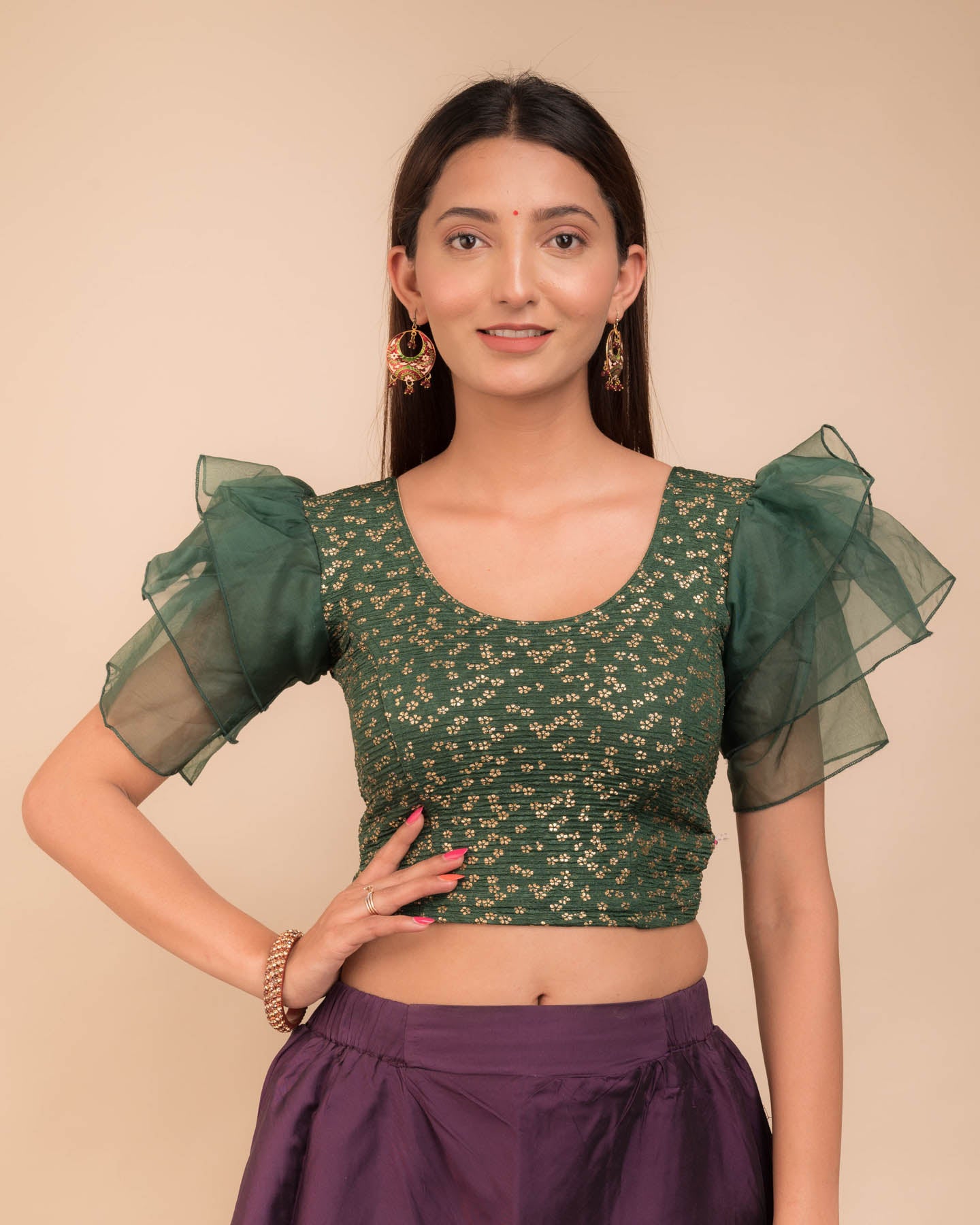 Model wearing an organza slip-on blouse with ruffled sleeves and round neckline