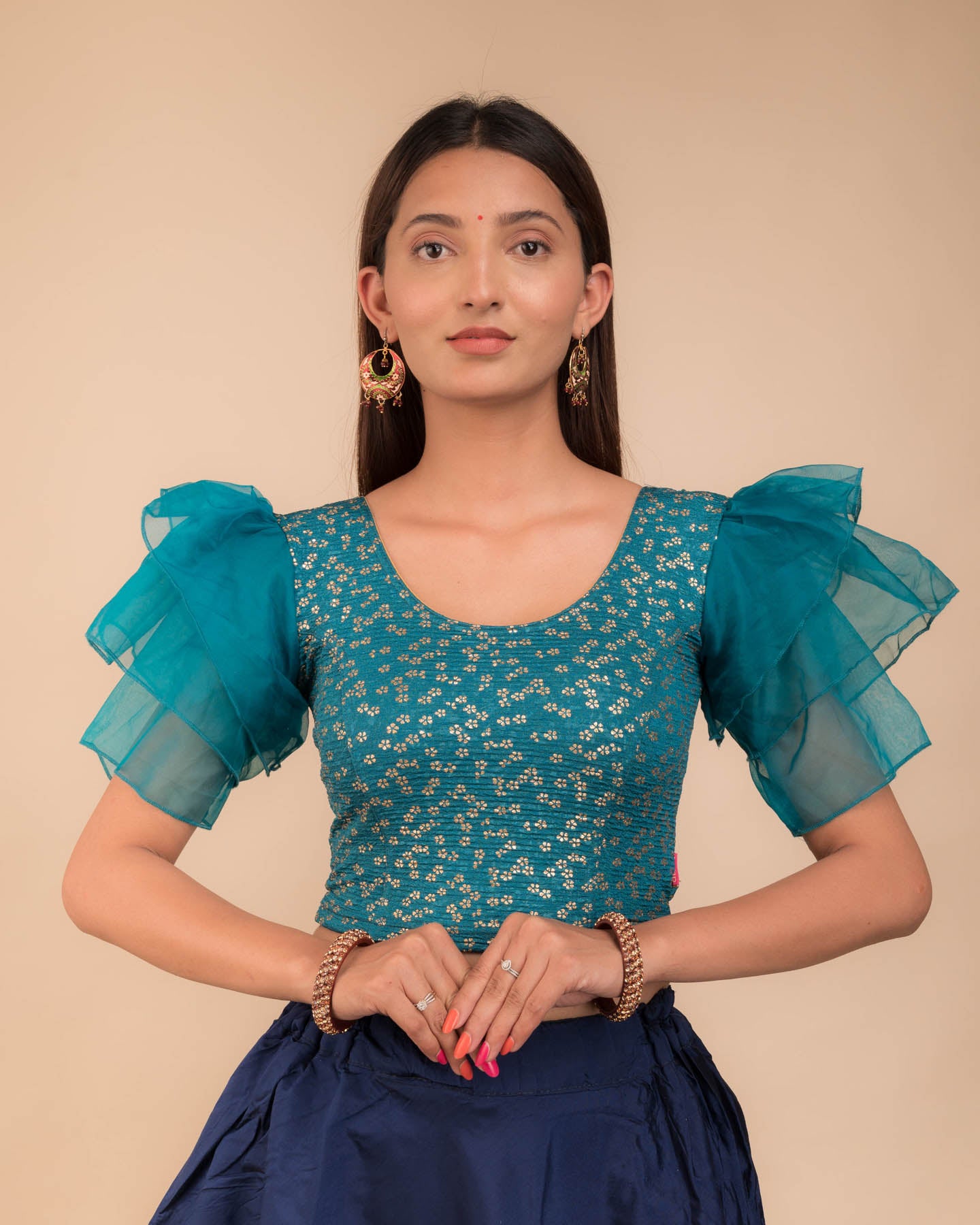 Model wearing an organza slip-on blouse with ruffled sleeves and round neckline