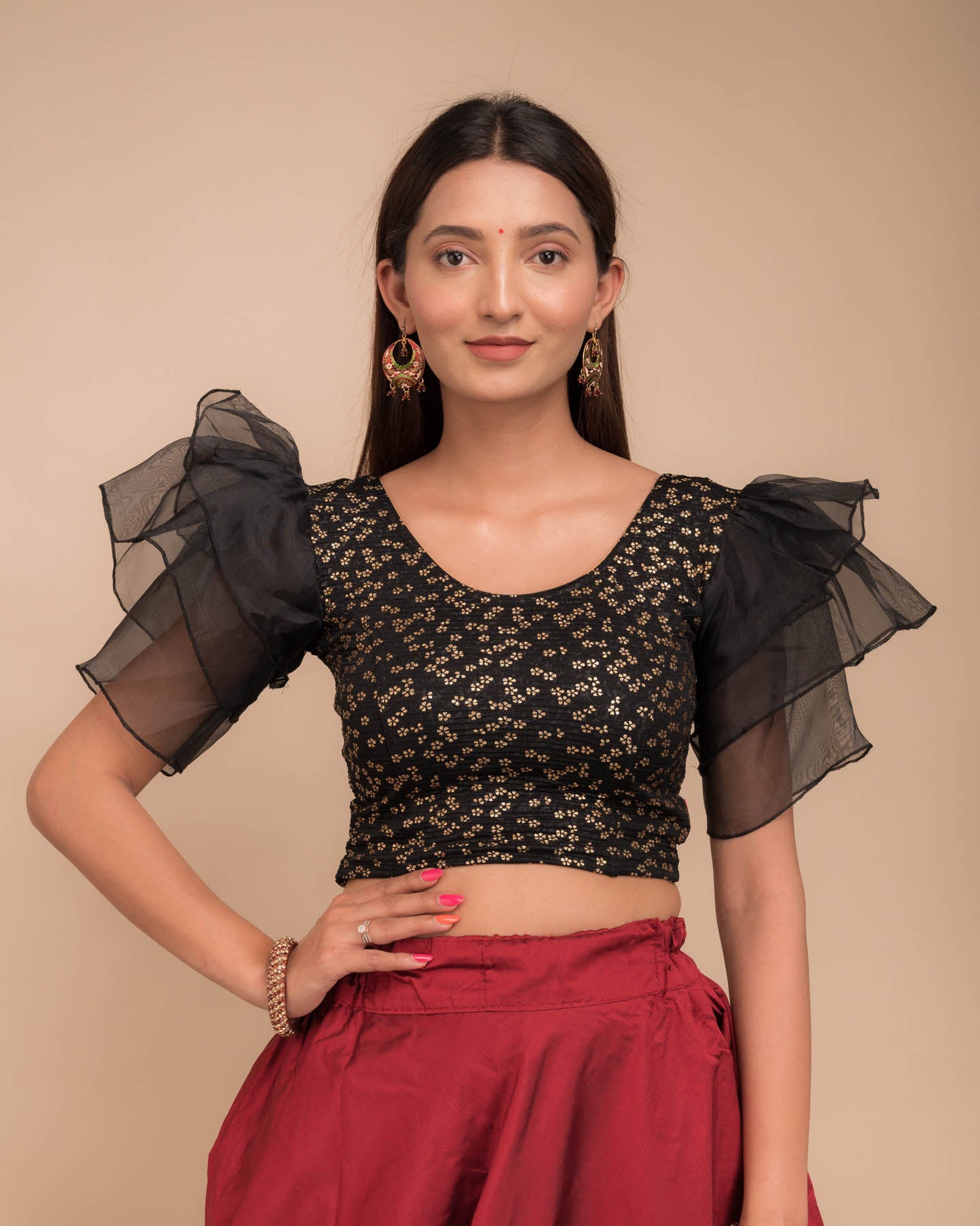 Model wearing an organza slip-on blouse with ruffled sleeves and round neckline