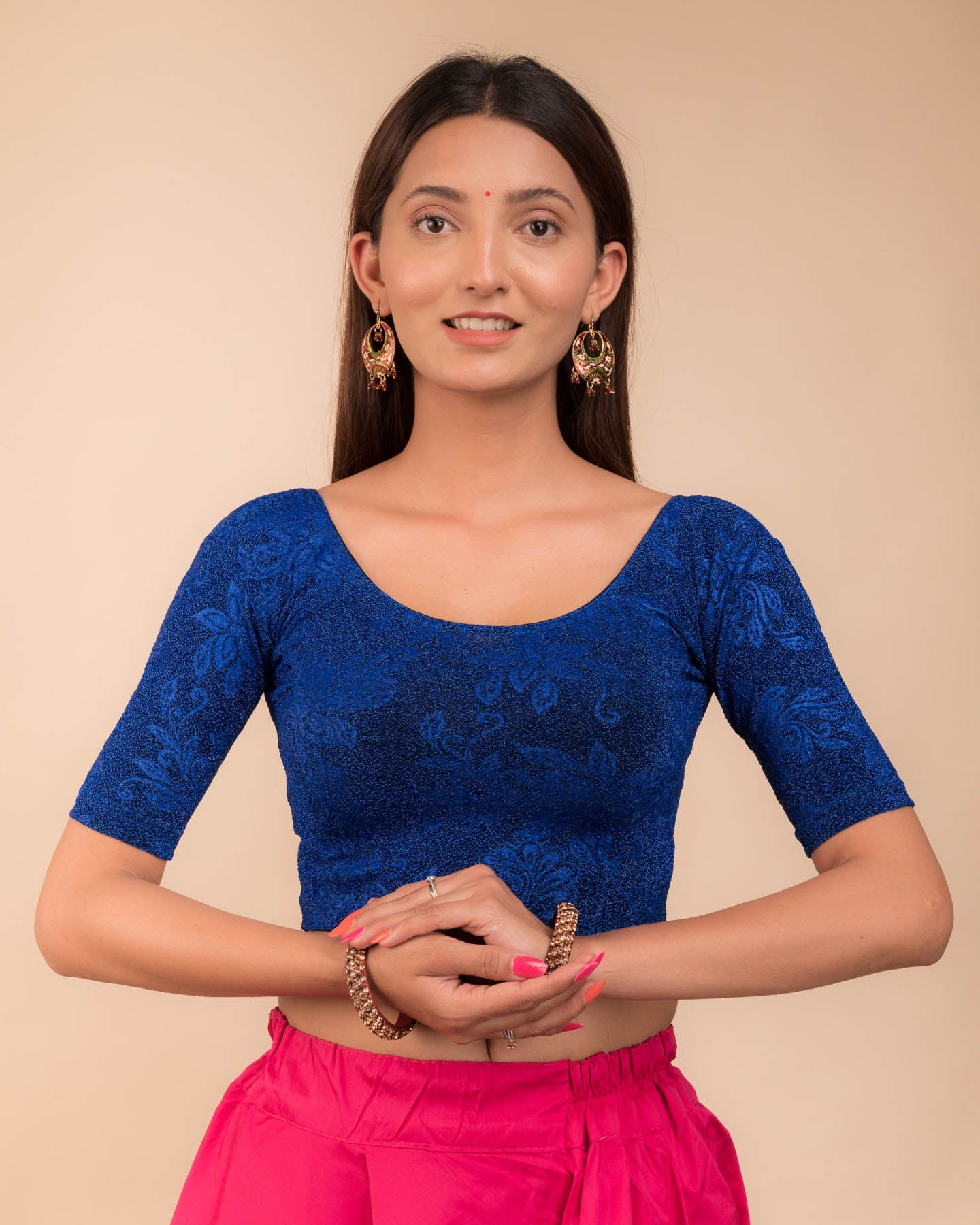 Model wearing a stretchable lurex blouse with elbow sleeves and round neckline, featuring delicate emboss details.