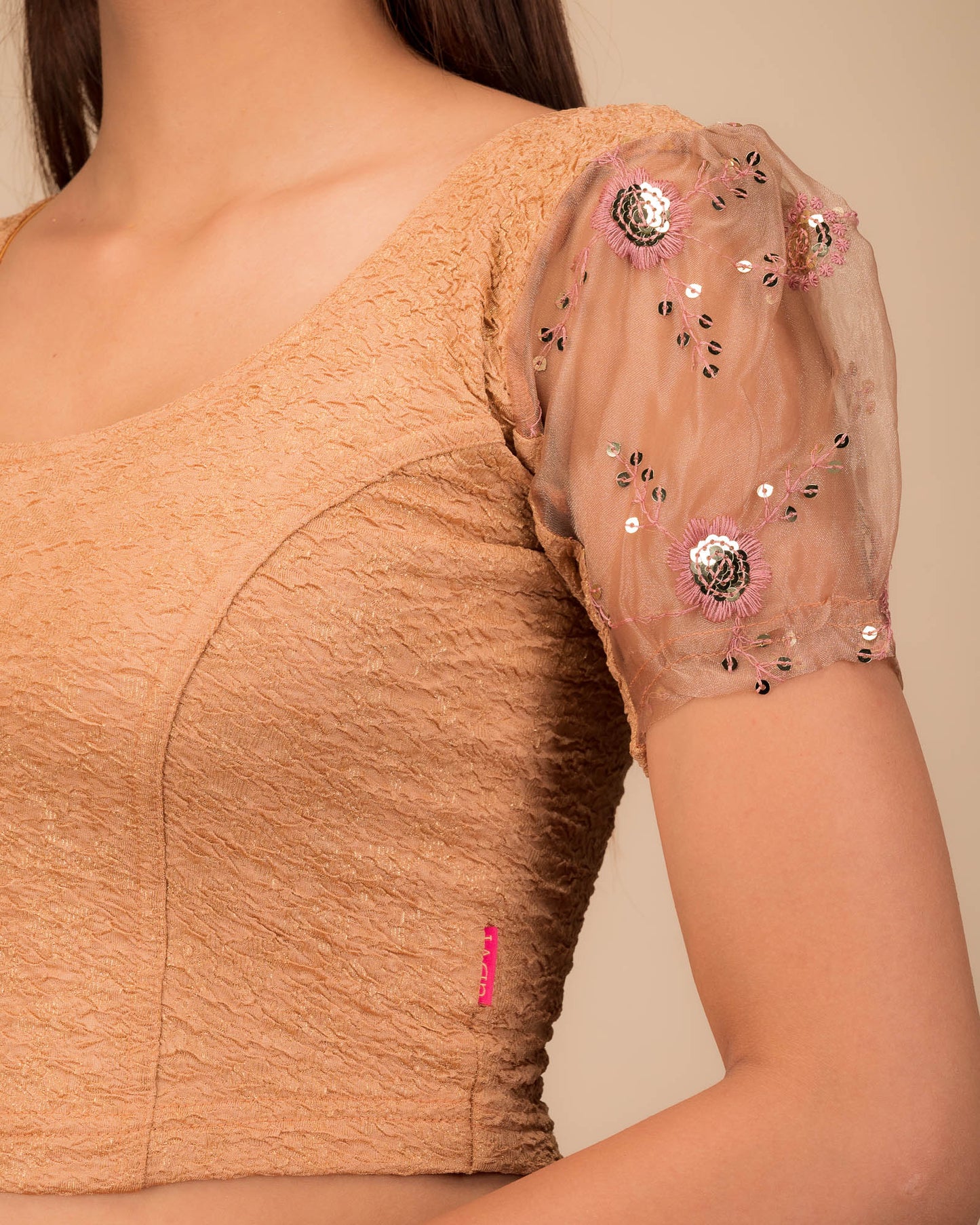 Close-up of textured bodice with sequin embroidery.