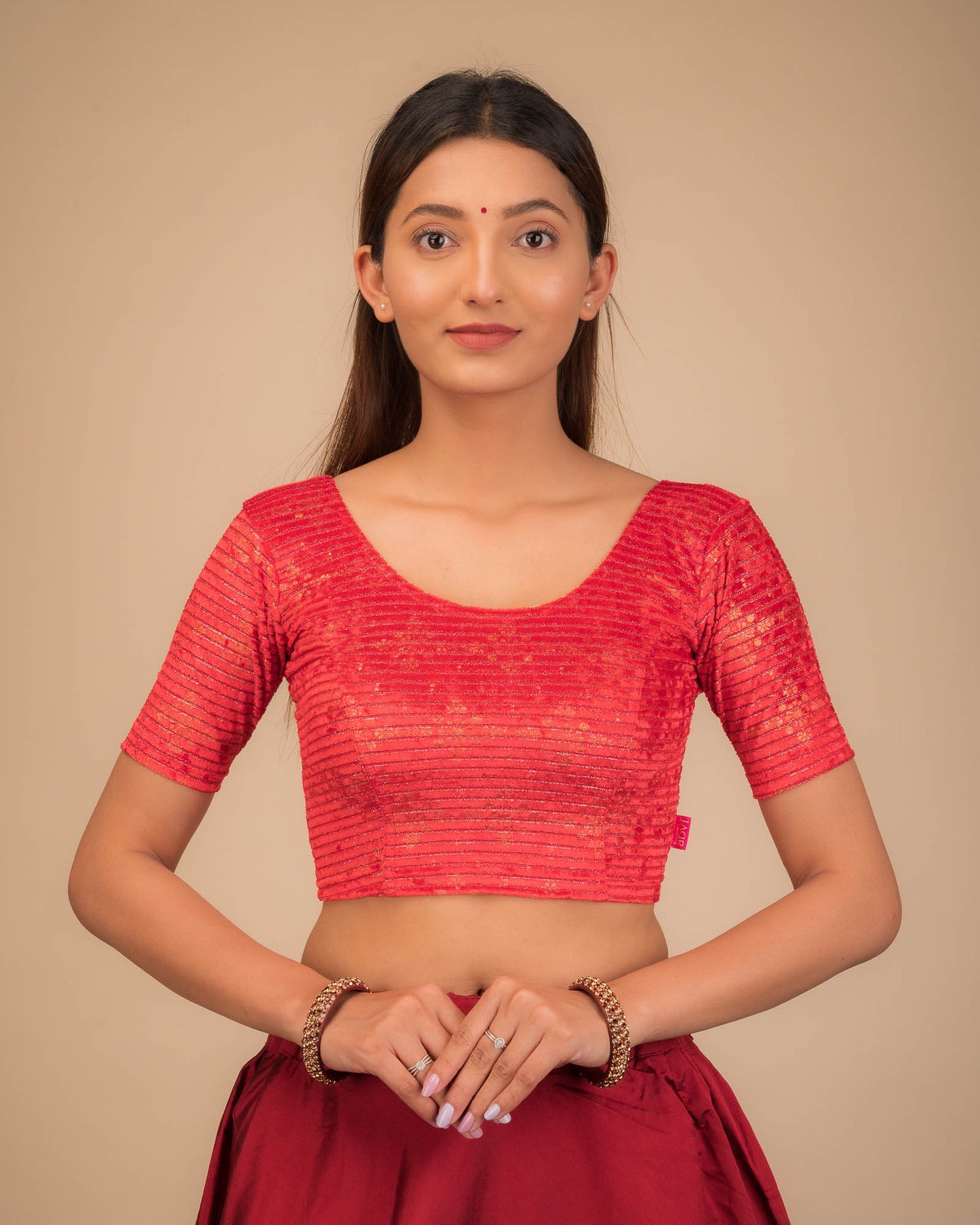 Model wearing a stretchable velvet blouse with elbow sleeves and round neckline.