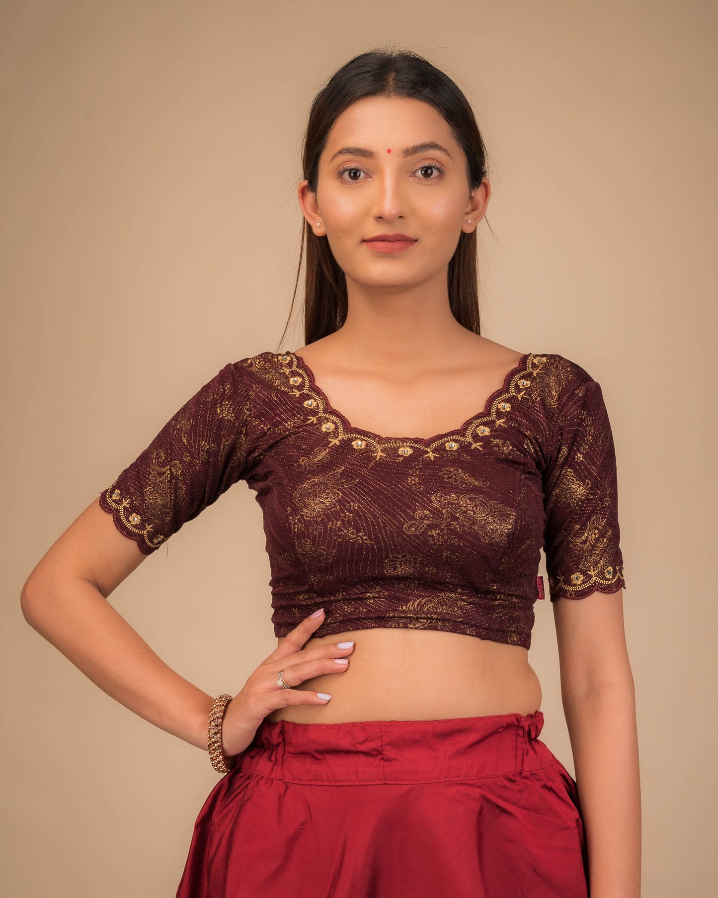 Model wearing a stretchable blouse with scalloped sleeves and round neckline featuring embroidery.