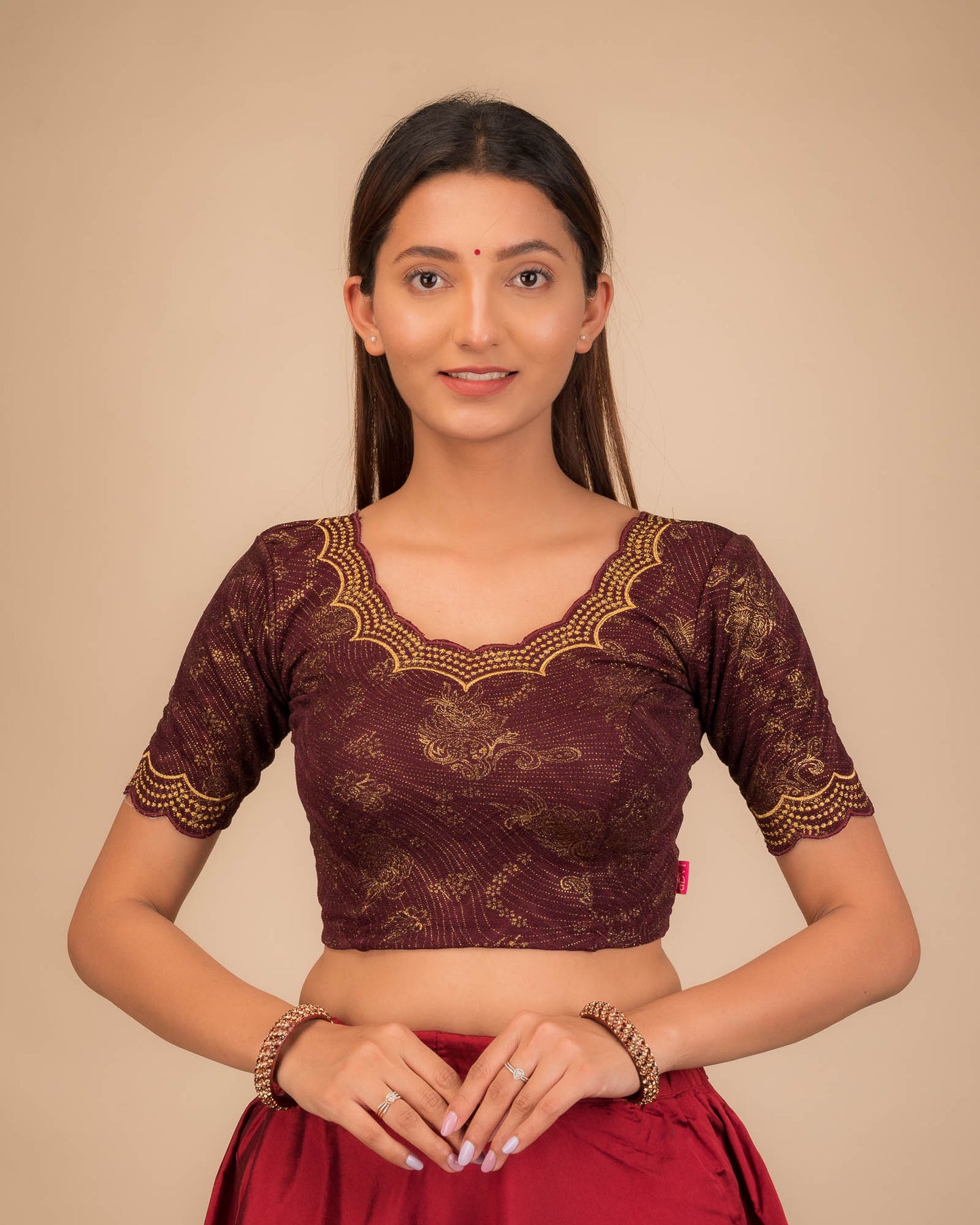 Model wearing a stretchable blouse with elbow sleeves and round neckline, featuring floral embroidery with stone accents.