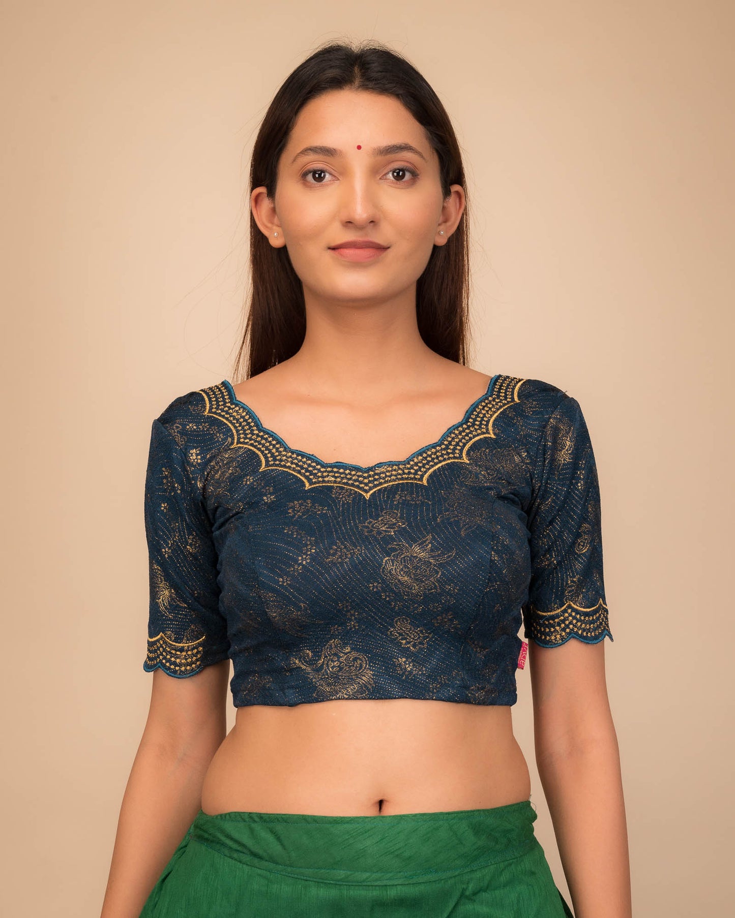 Model wearing a stretchable blouse with elbow sleeves and round neckline, featuring floral embroidery with stone accents.