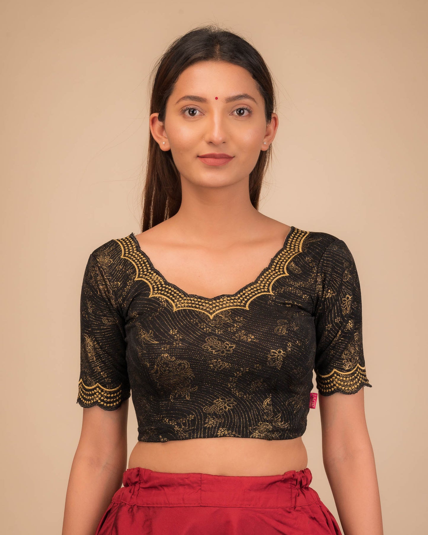 Model wearing a stretchable blouse with elbow sleeves and round neckline, featuring floral embroidery with stone accents.