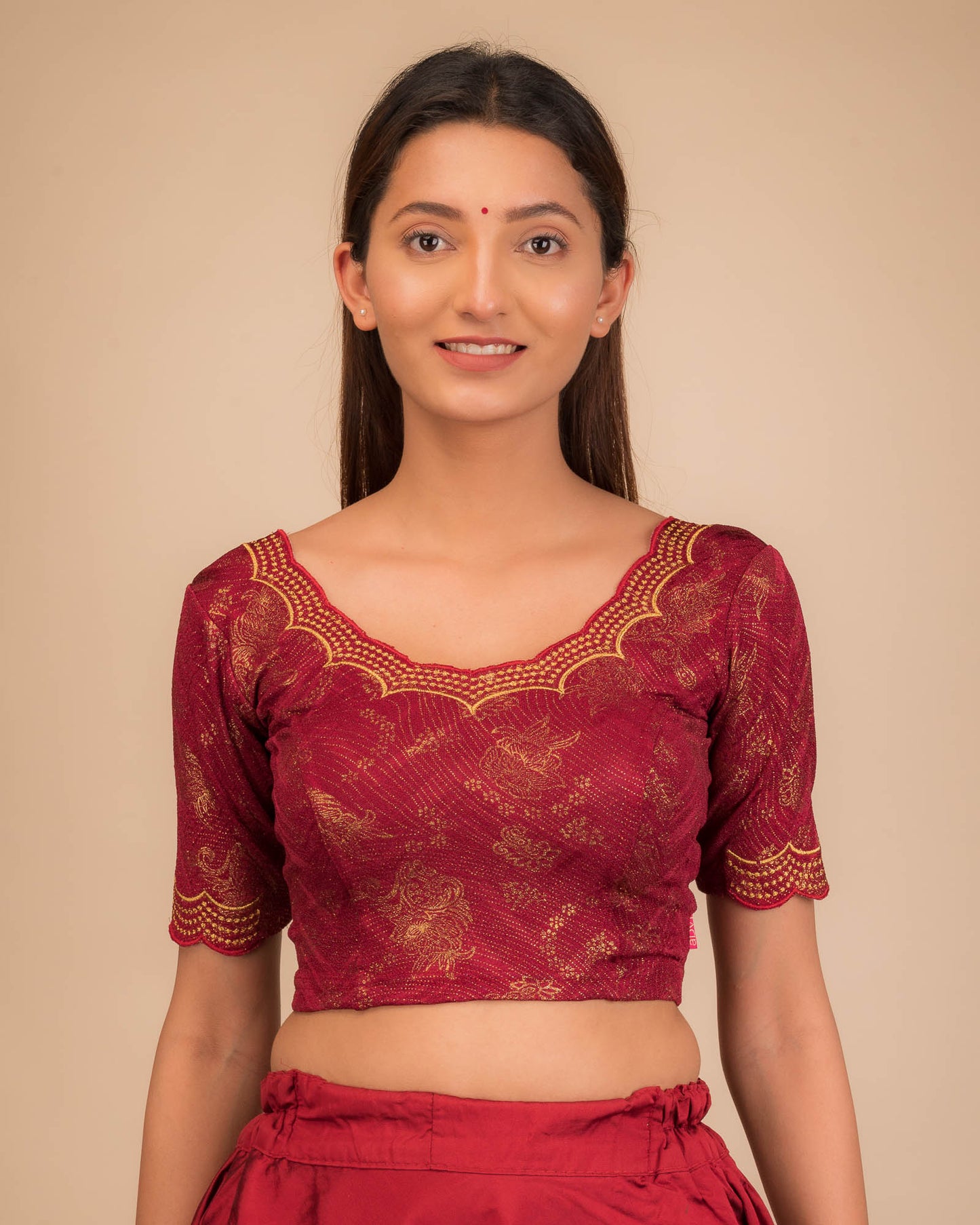 Model wearing a stretchable blouse with elbow sleeves and round neckline, featuring floral embroidery with stone accents.