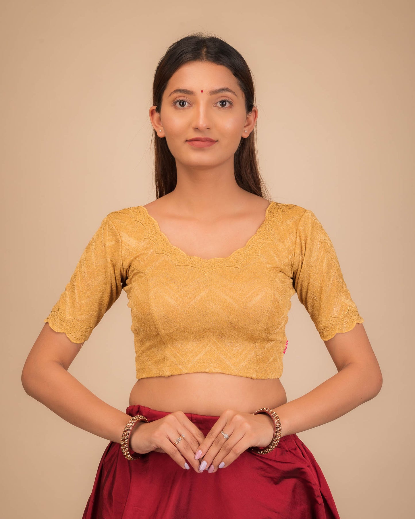 Model wearing a stretchable blouse with elbow sleeves and round neckline, featuring floral embroidery with stone accents.