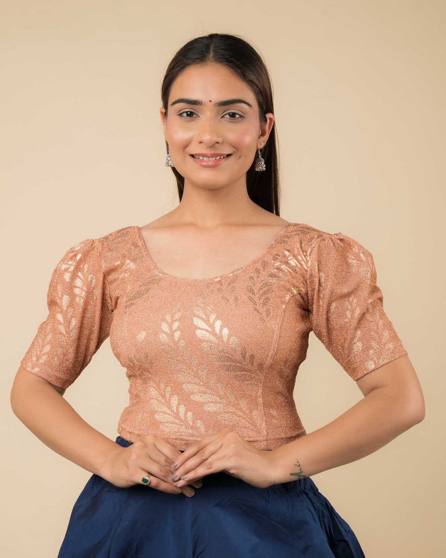 Model wearing metallic zari stretchable blouse with rose print, round neck and elbow sleeves, styled for festive sarees.