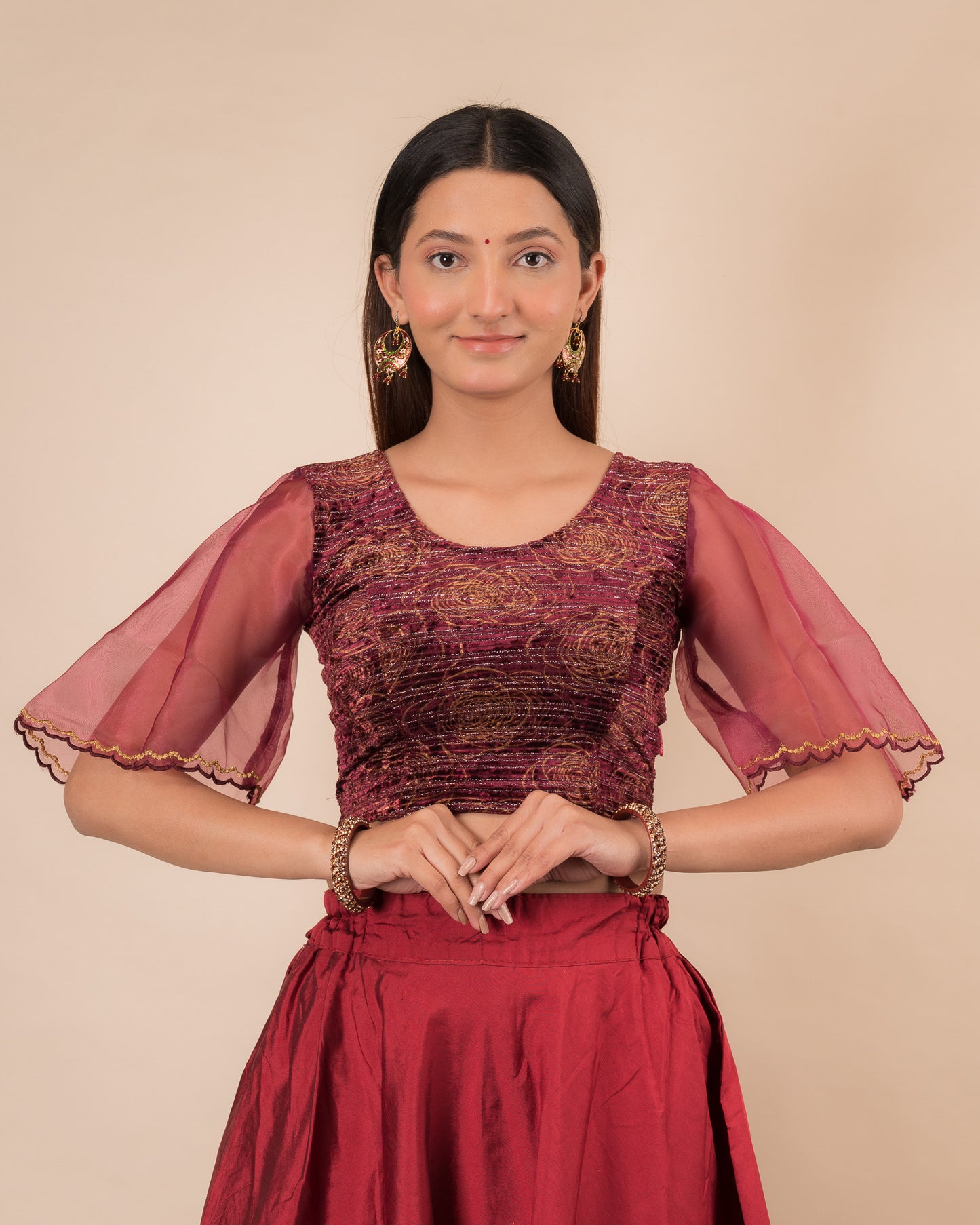 Model wearing a velvet slip-on blouse with elbow bell sleeves and round neckline.