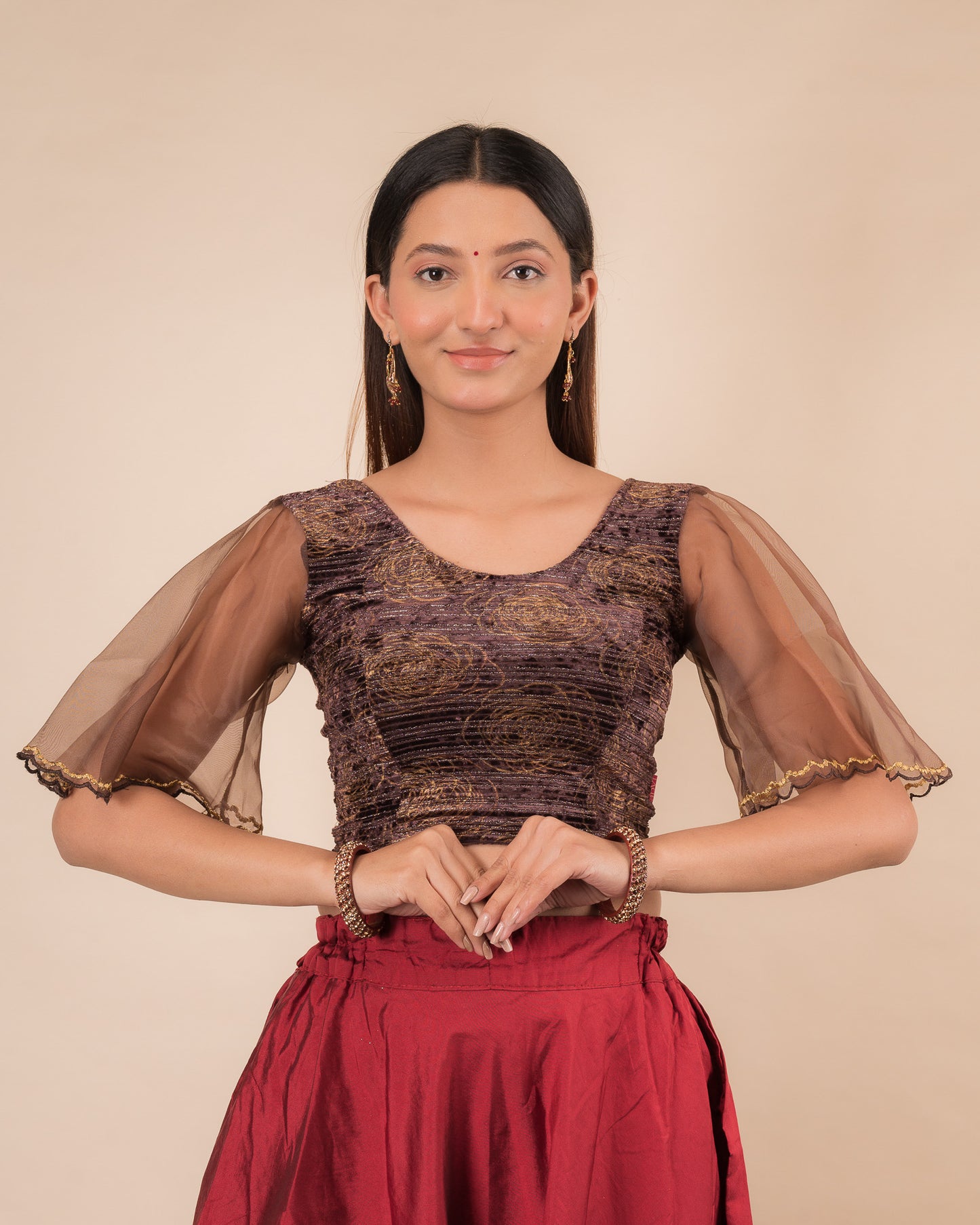 Model wearing a velvet slip-on blouse with elbow bell sleeves and round neckline.