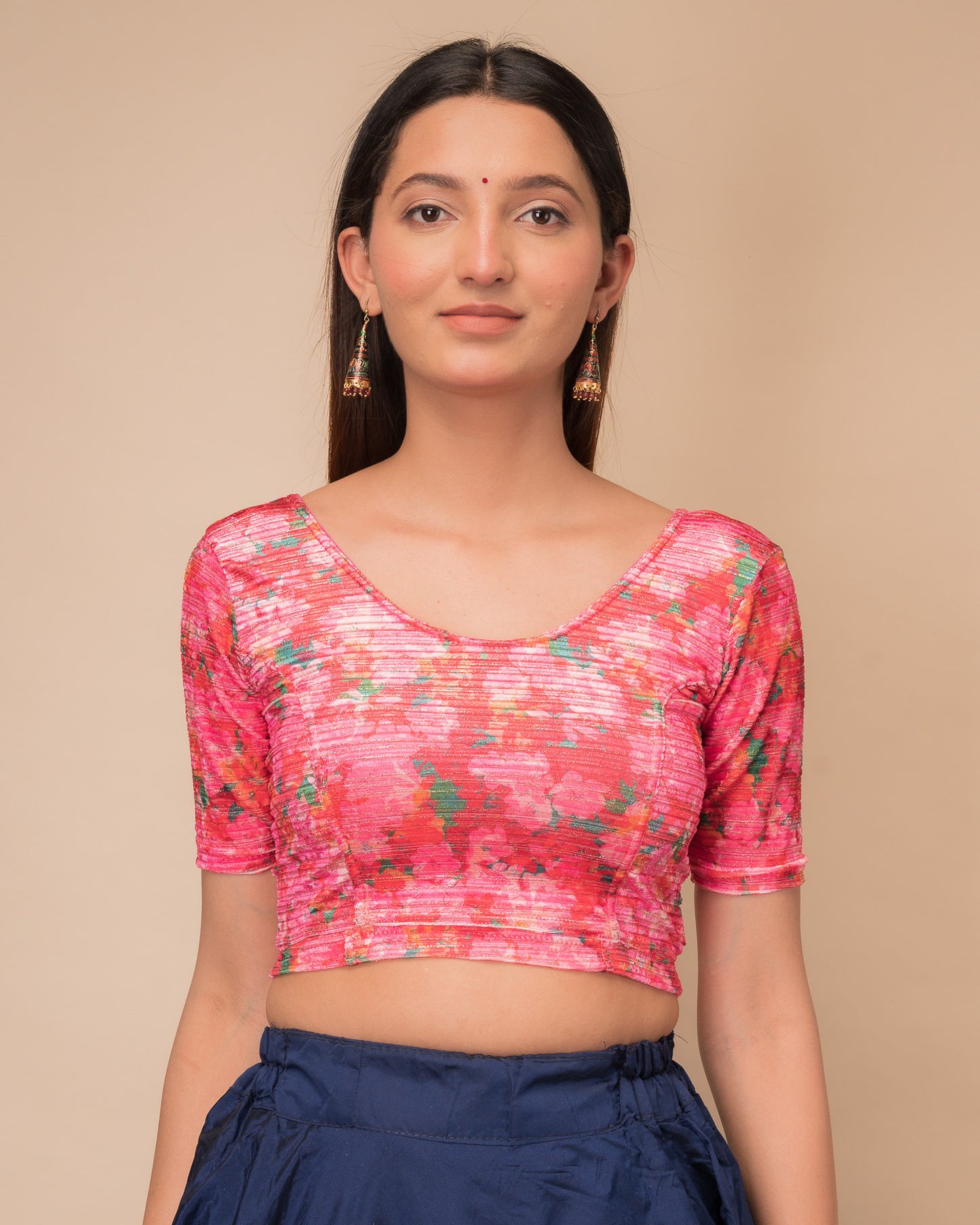 Model wearing a stretchable velvet blouse with elbow sleeves and round neckline, showcasing a floral print.
