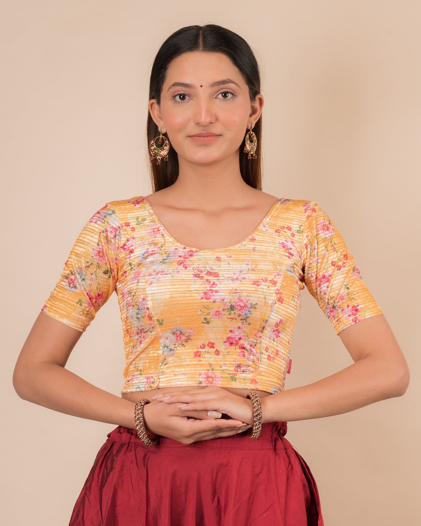 Model wearing a stretchable velvet blouse with elbow sleeves and round neckline, showcasing a floral print.