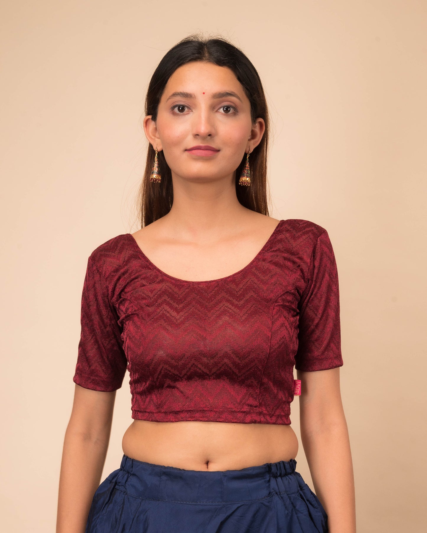 Model wearing a maroon melange zig-zag patterned stretchable readymade blouse with elbow sleeves and round neckline