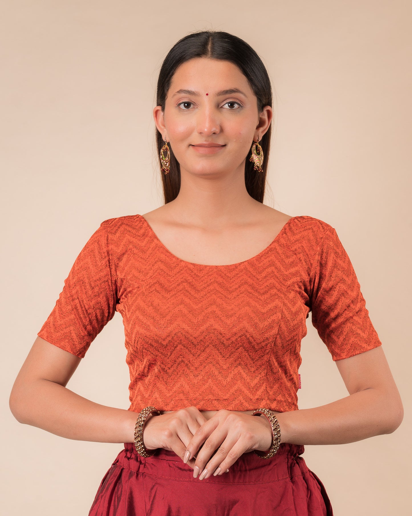 Model wearing a maroon melange zig-zag patterned stretchable readymade blouse with elbow sleeves and round neckline