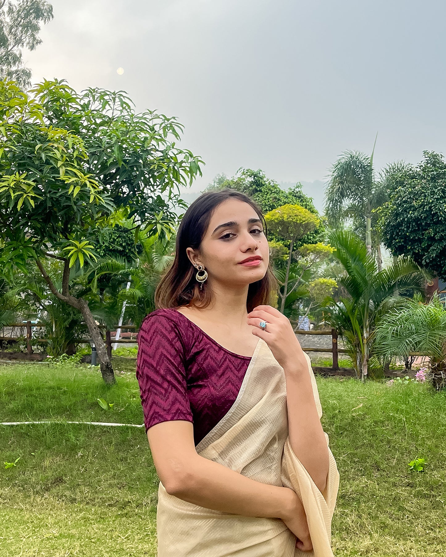 Model pairing the maroon melange zig-zag blouse with a traditional saree, demonstrating a complete ethnic look