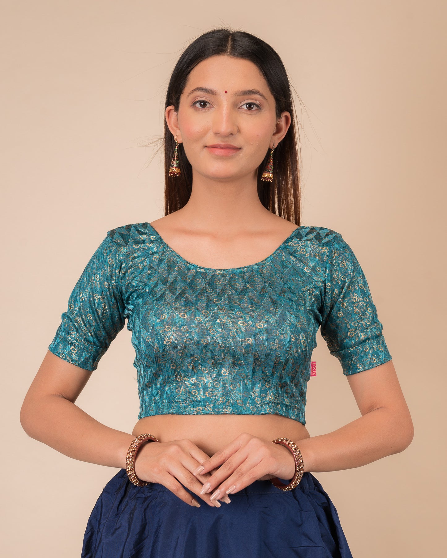 Model wearing a floral foil stretchable blouse with elbow sleeves, round neckline, and ruffle detail
