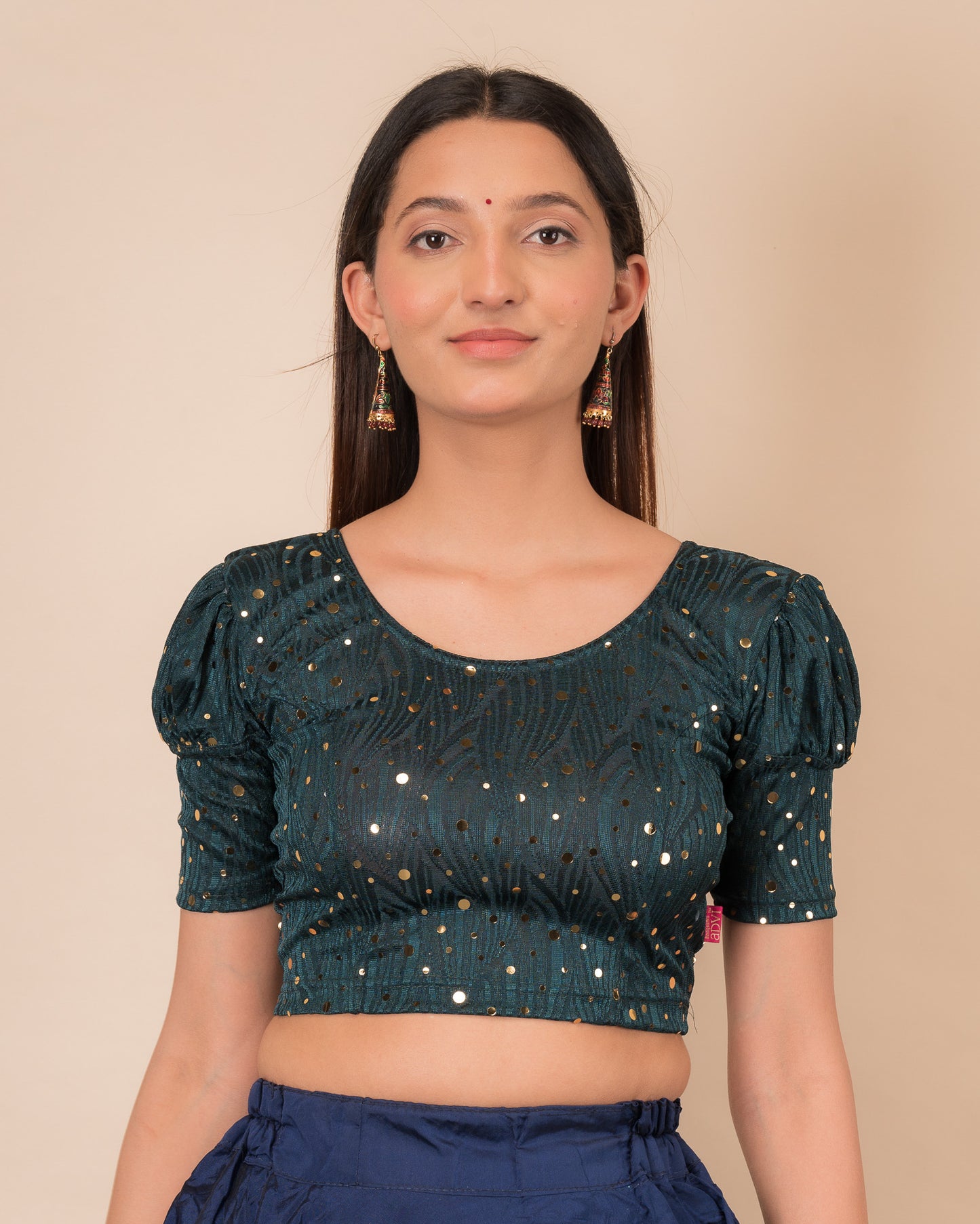 Model wearing a red stretchable blouse with gold mirror embellishments, puff sleeves, and round neckline