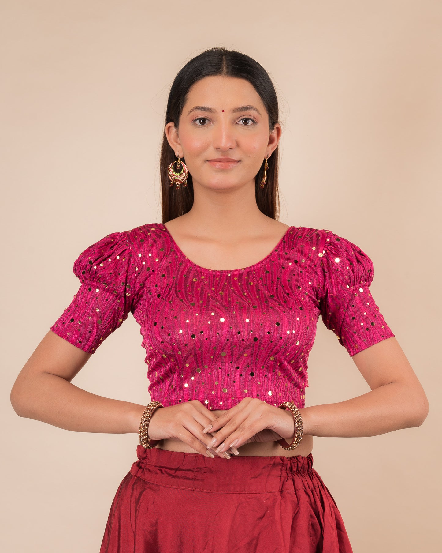 Model wearing a red stretchable blouse with gold mirror embellishments, puff sleeves, and round neckline