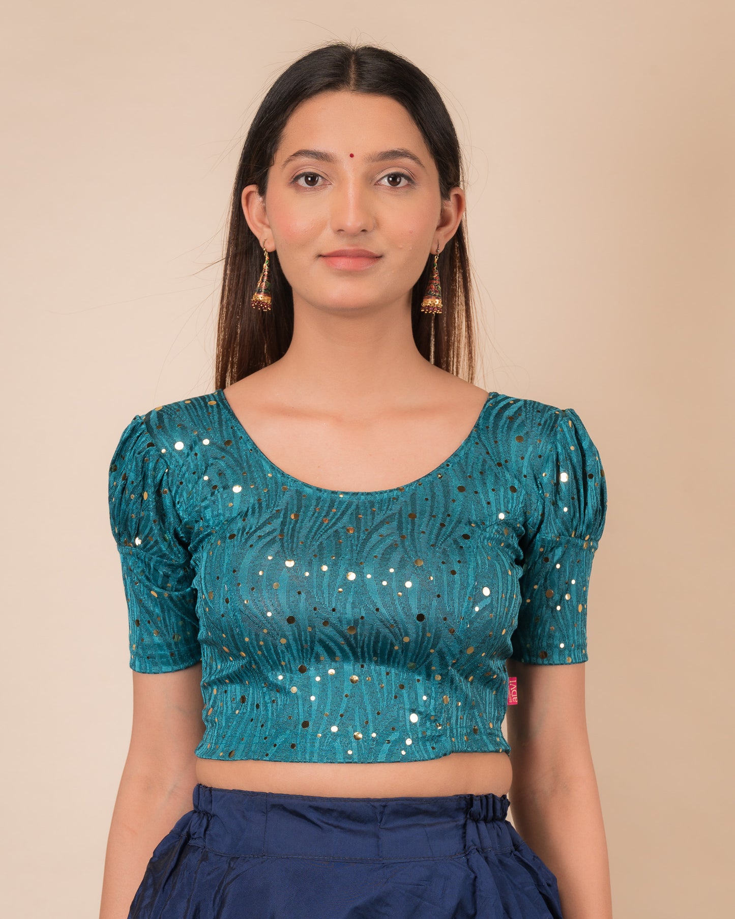 Model wearing a red stretchable blouse with gold mirror embellishments, puff sleeves, and round neckline