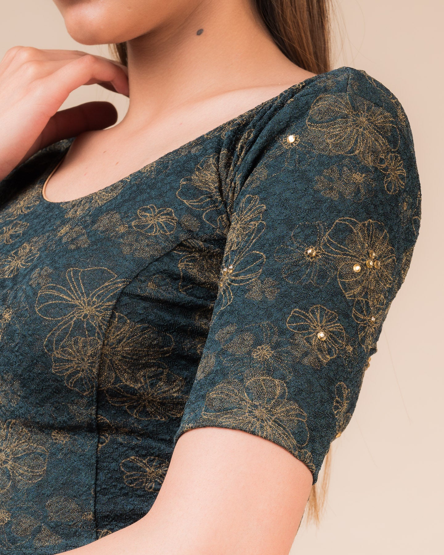 Close-up detailing the floral foil texture and stone work on jacquard fabric