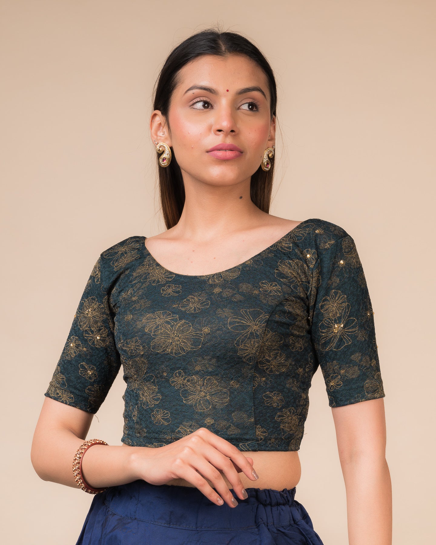 Model wearing a maroon foil and stone-embellished stretchable blouse with elbow sleeves and round neckline