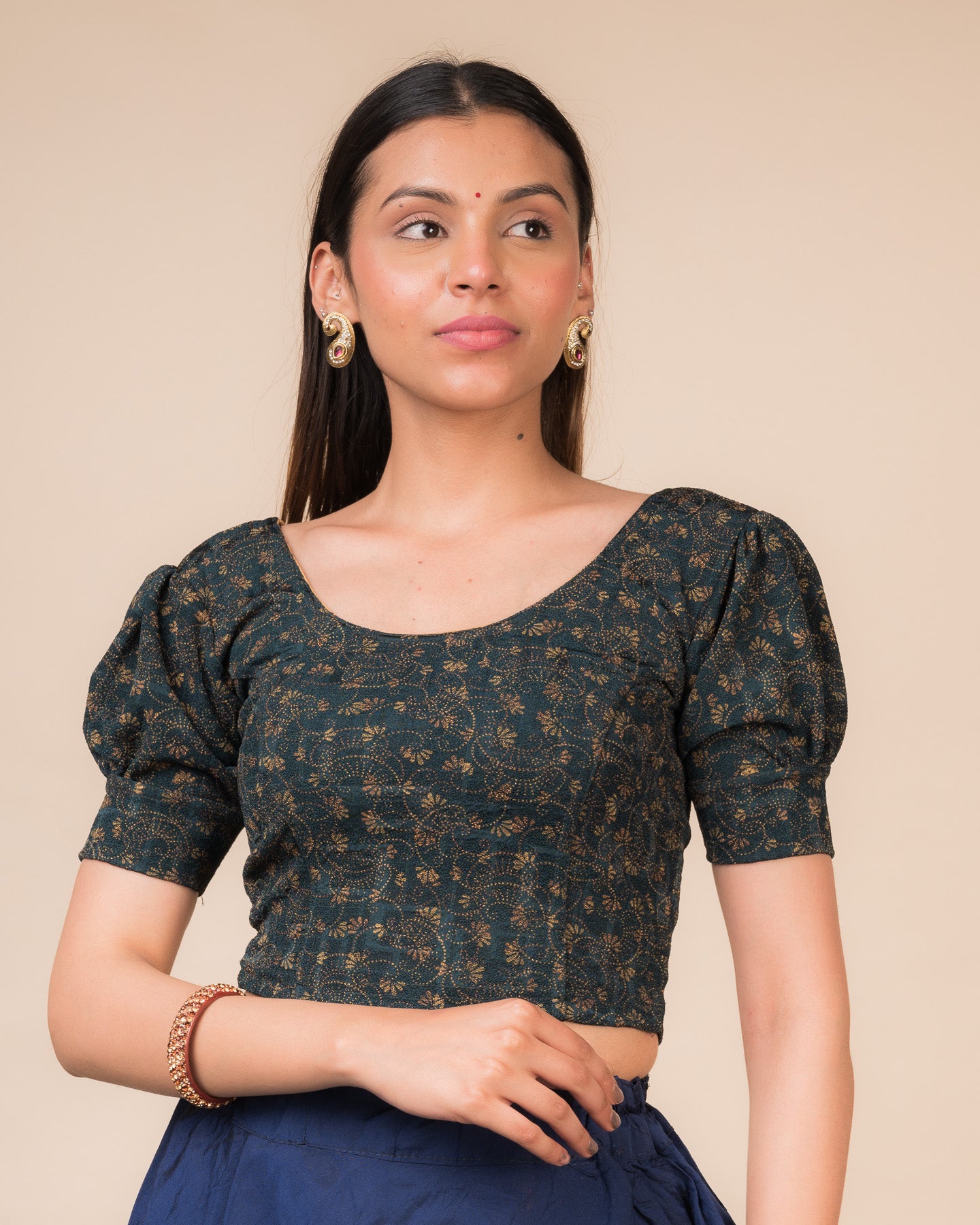 Model wearing a navy stretchable blouse with elbow sleeves, metallic print, and round neckline