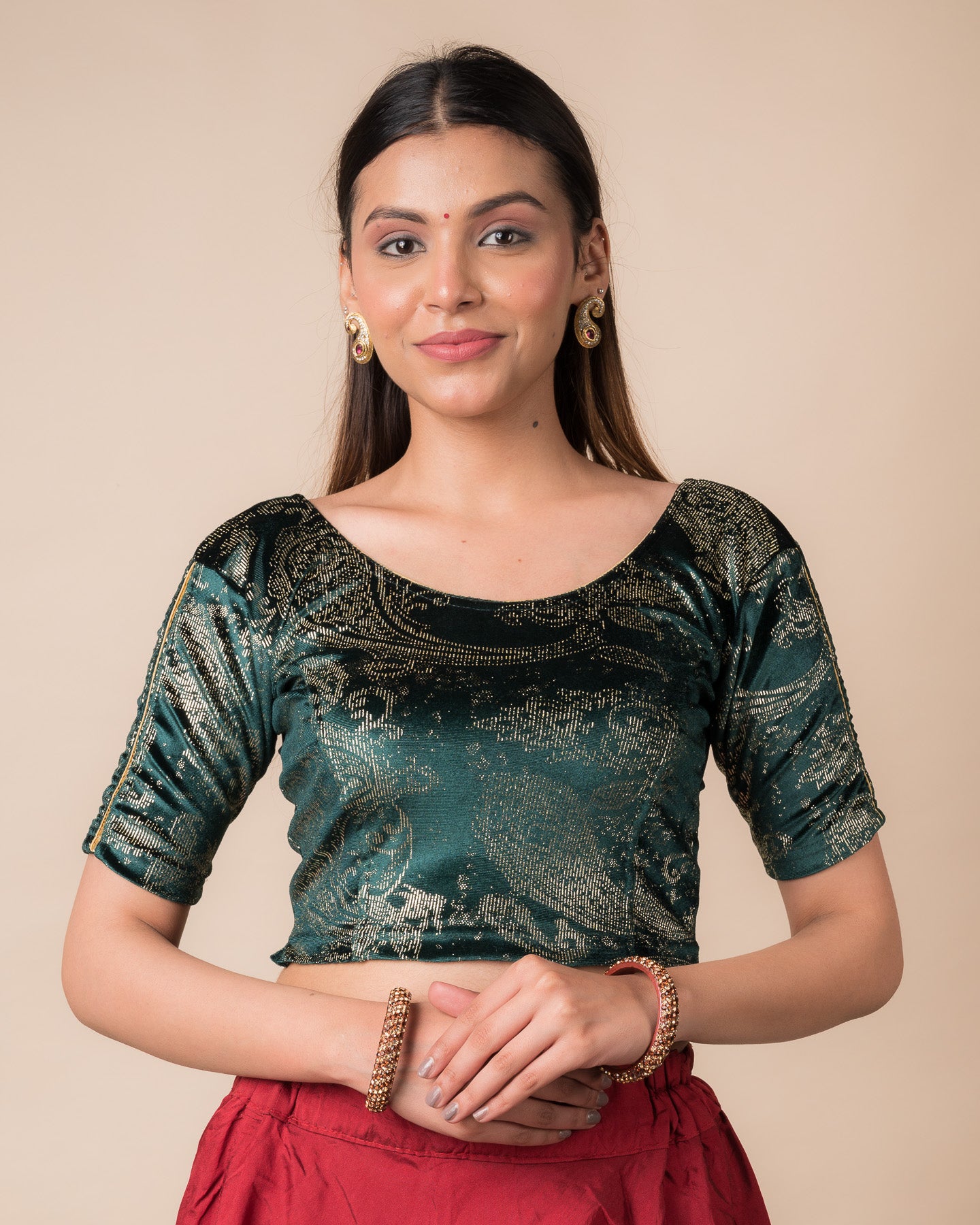 Model wearing a maroon velvet stretchable blouse with gold paisley prints, elbow sleeves, and round neckline.