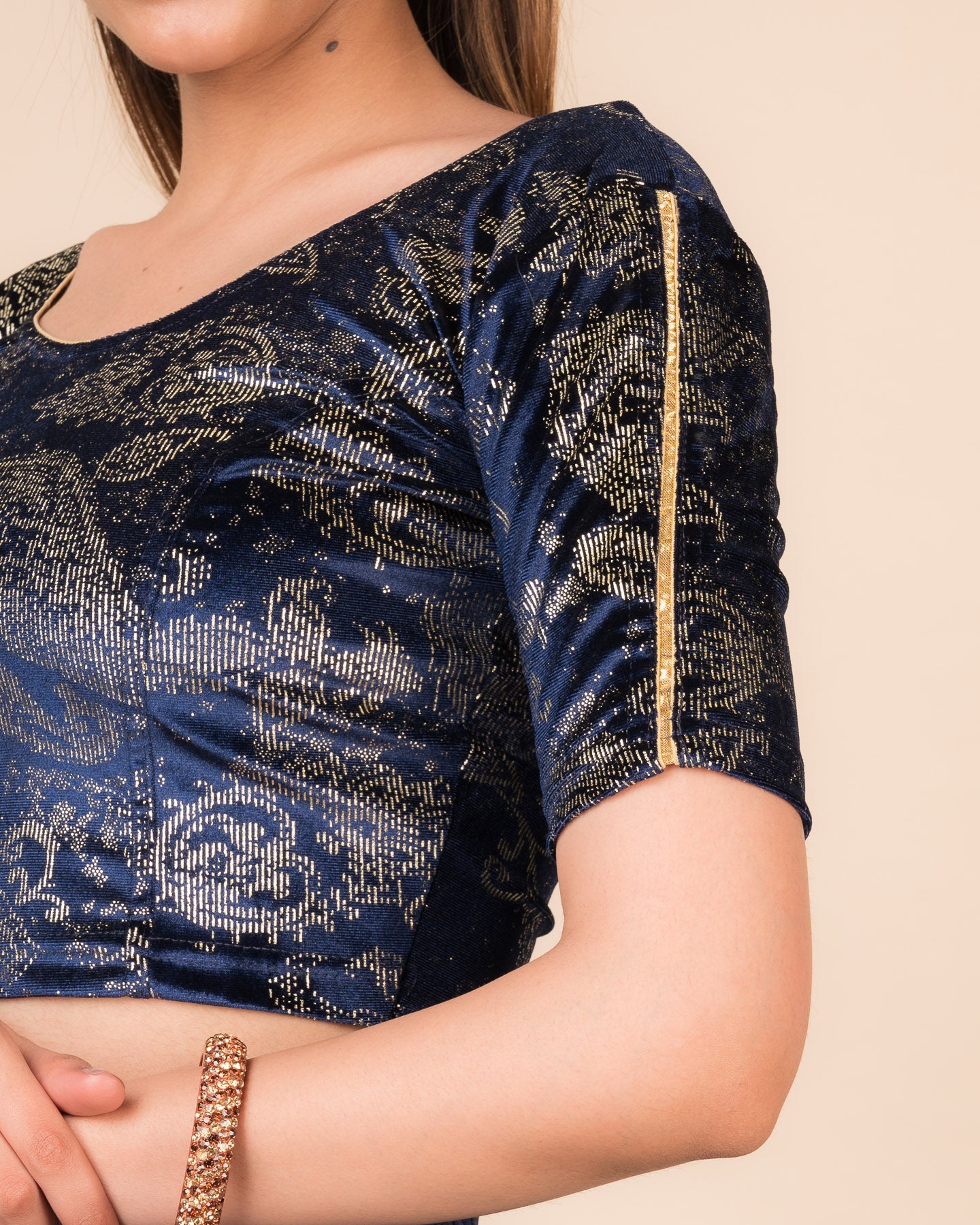 Close-up of velvet texture with gold paisley prints and gota accents