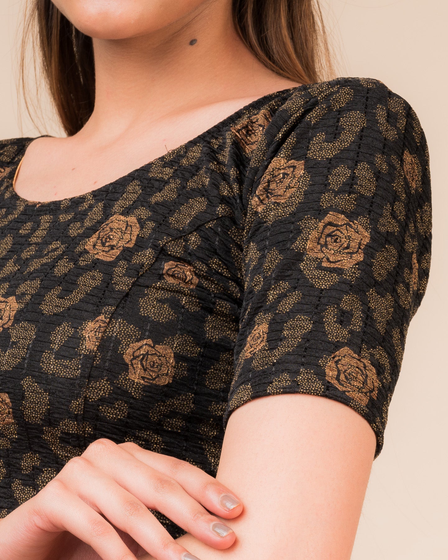 Close-up of the fabric’s metallic floral foil design and stretchable texture