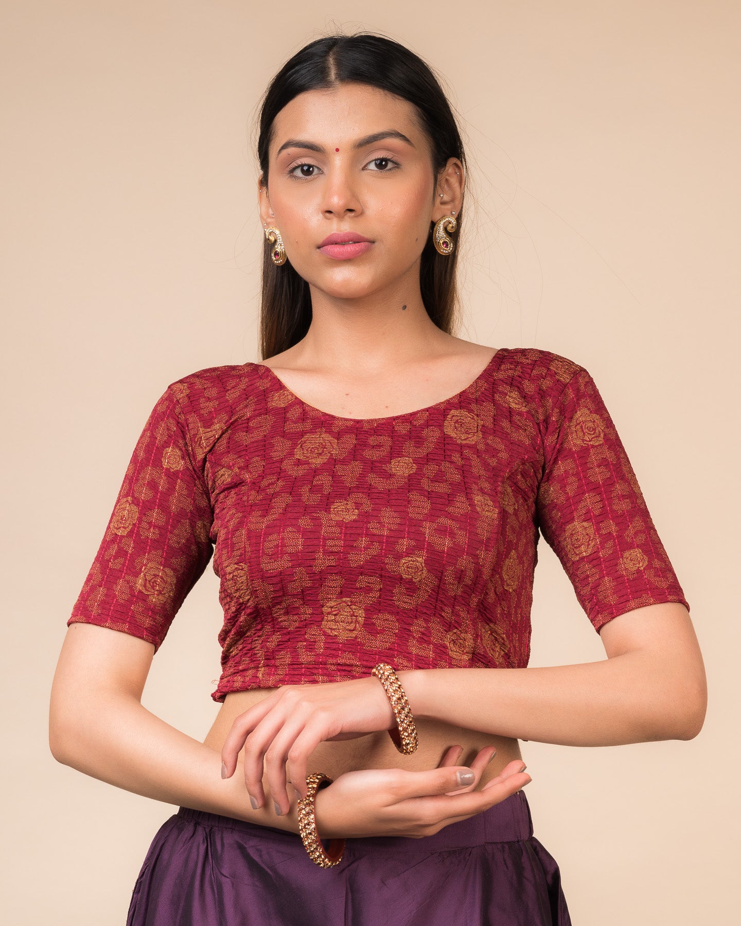 Model wearing a red stretchable blouse with metallic foil floral print, elbow sleeves, and round neckline