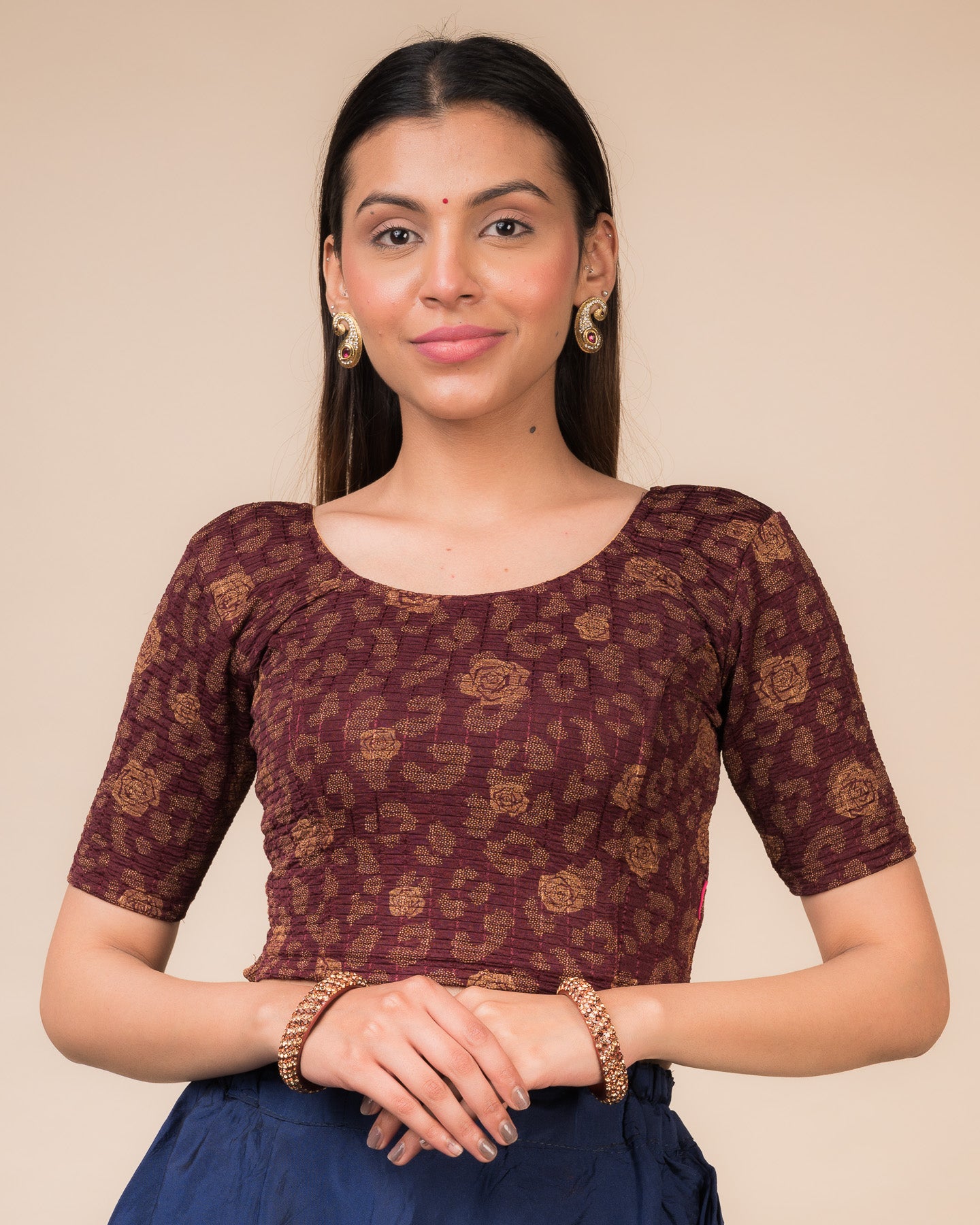 Model wearing a red stretchable blouse with metallic foil floral print, elbow sleeves, and round neckline