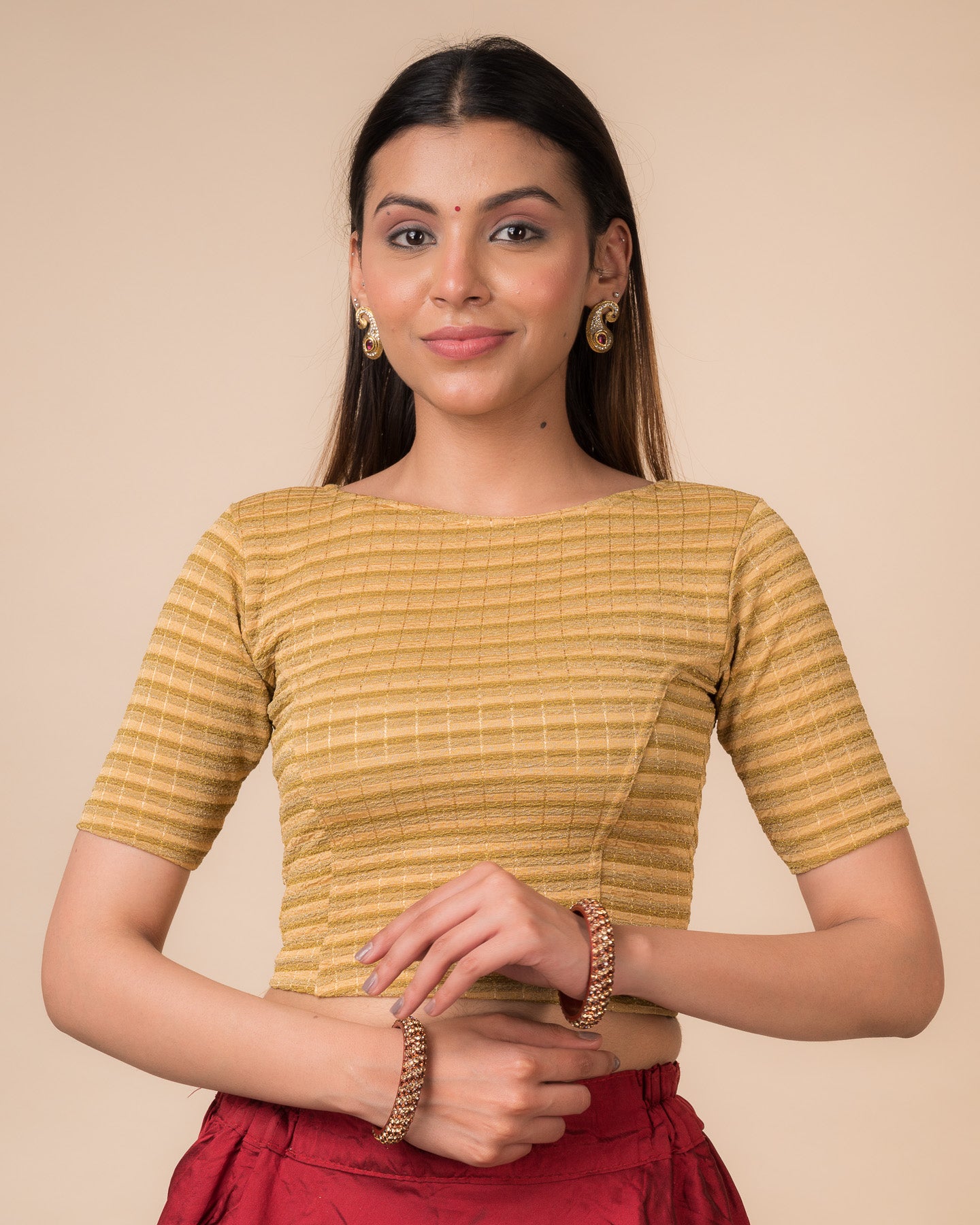 Model wearing a metallic-striped stretchable blouse with elbow sleeves and boat neckline