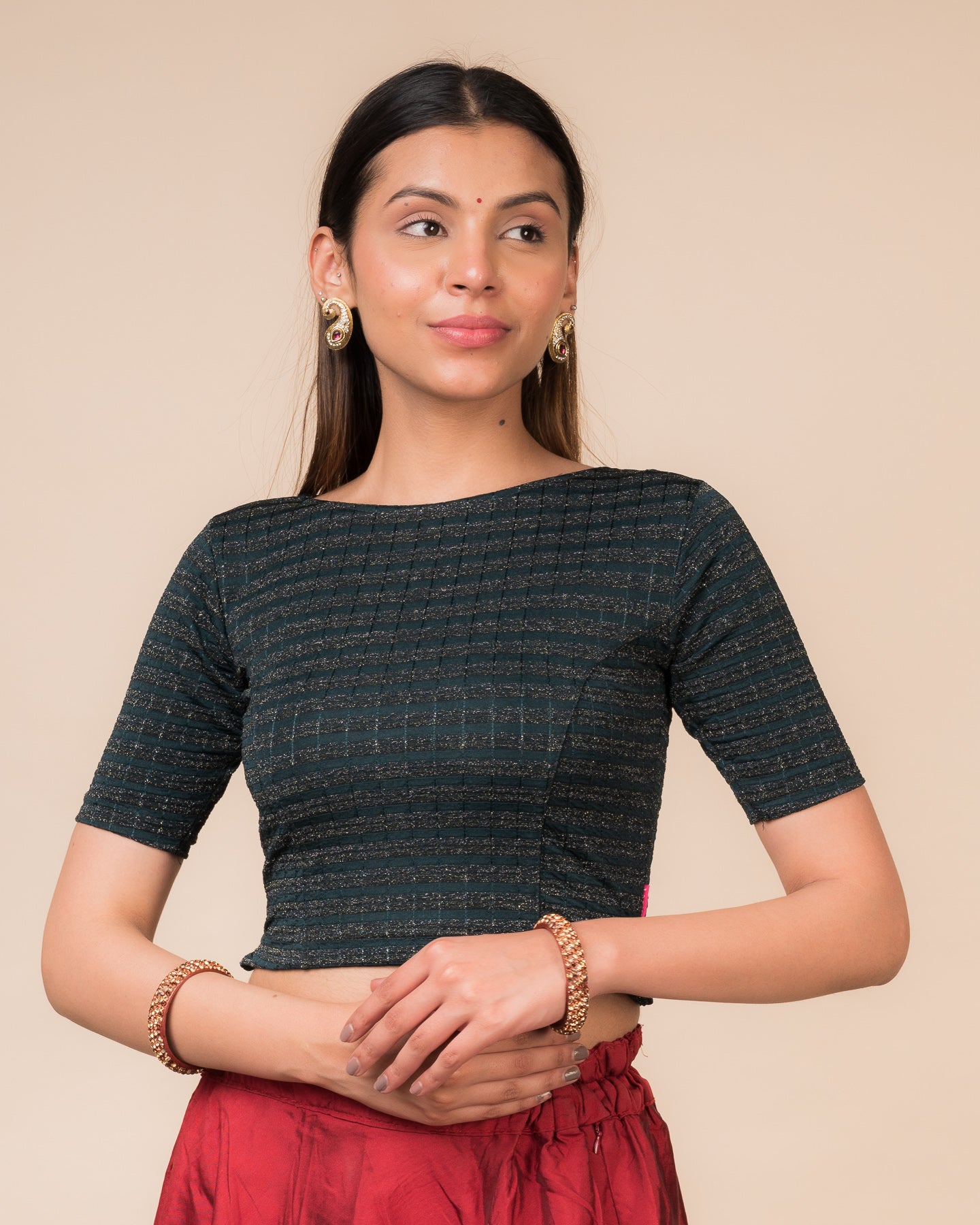 Model wearing a metallic-striped stretchable blouse with elbow sleeves and boat neckline