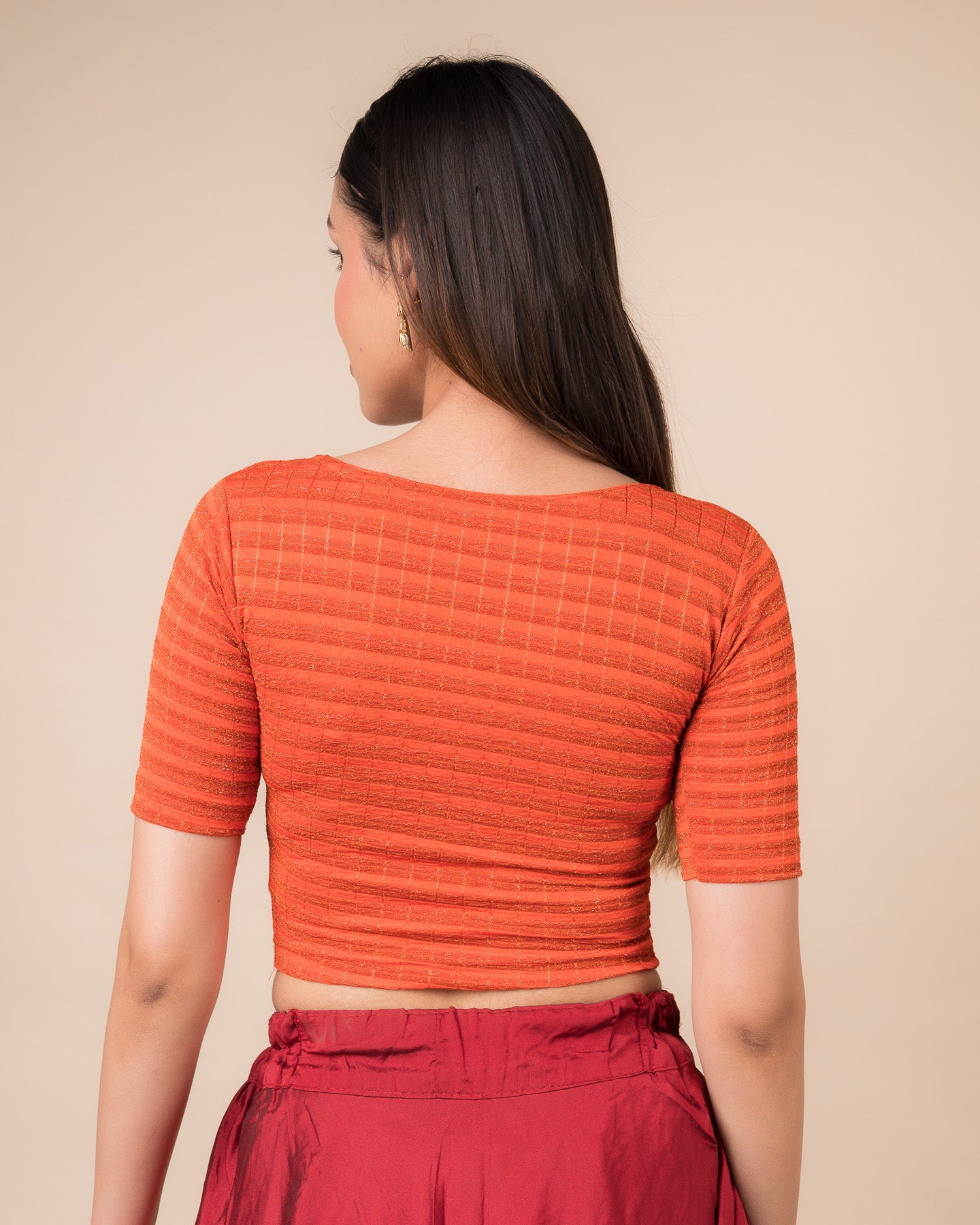 Rear view showcasing the back design of the metallic stripe blouse