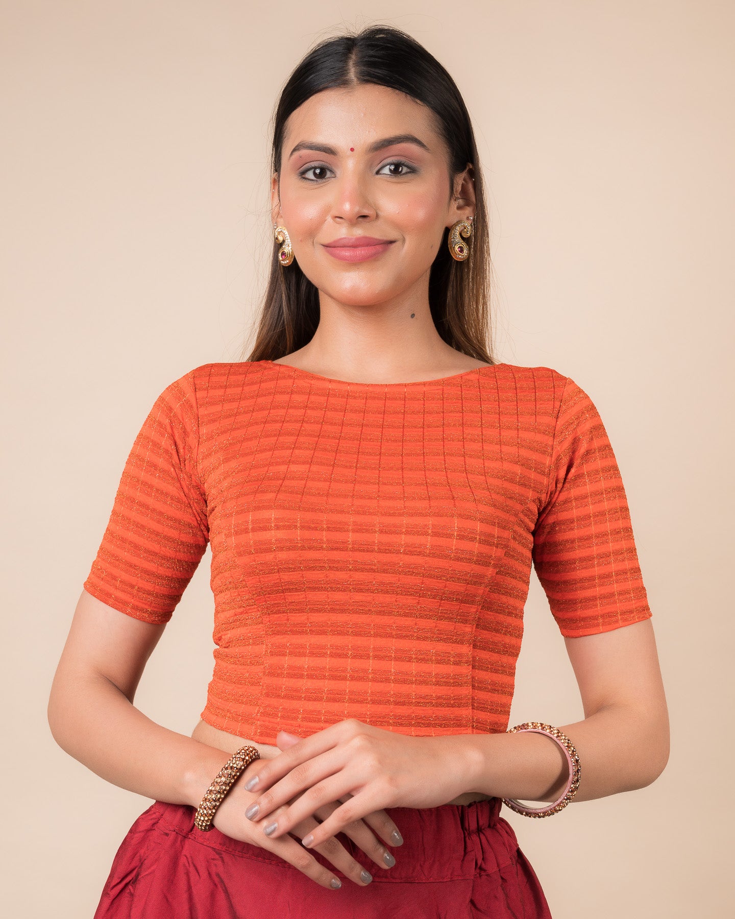 Model wearing a metallic-striped stretchable blouse with elbow sleeves and boat neckline