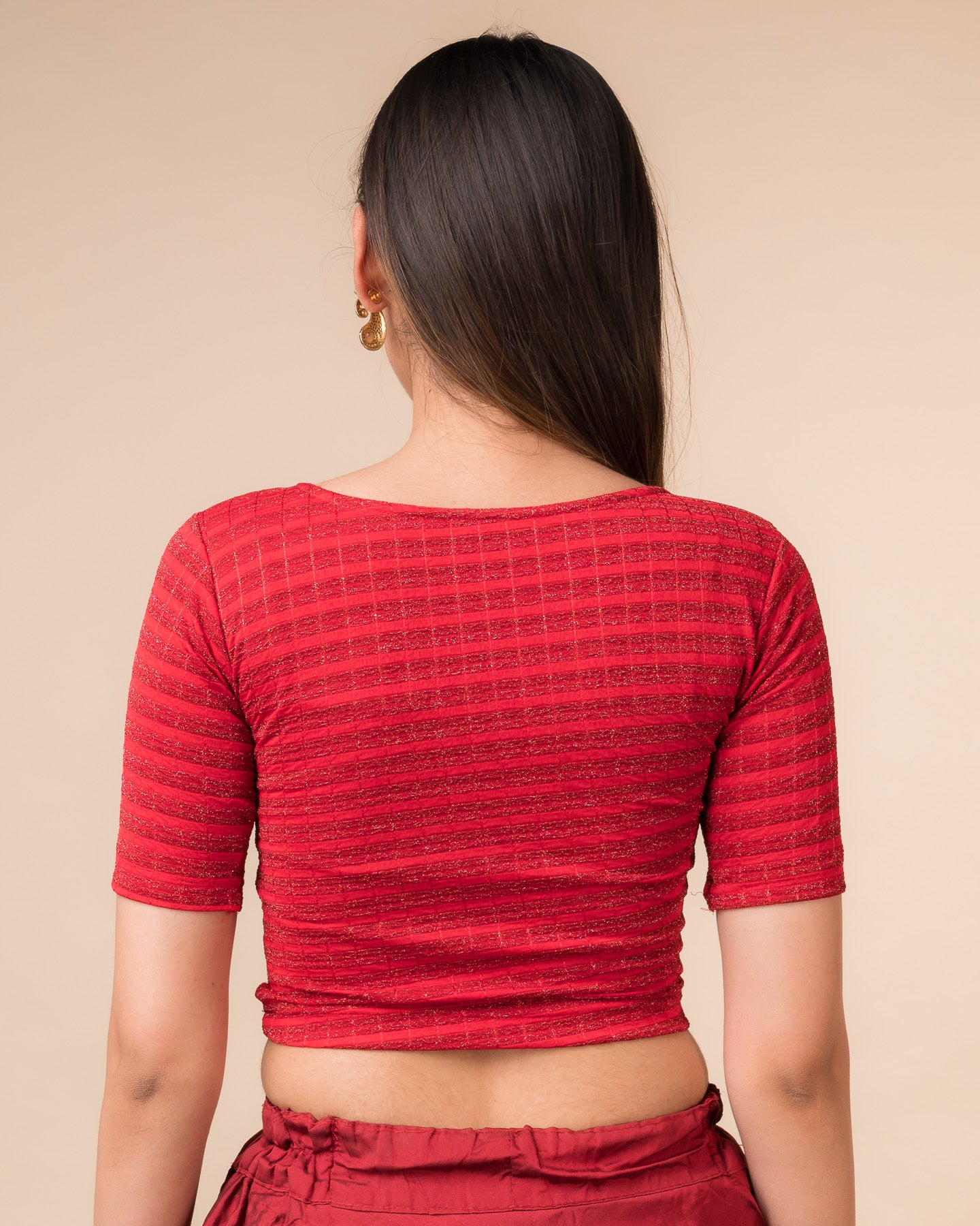 Rear view showcasing the back design of the metallic stripe blouse