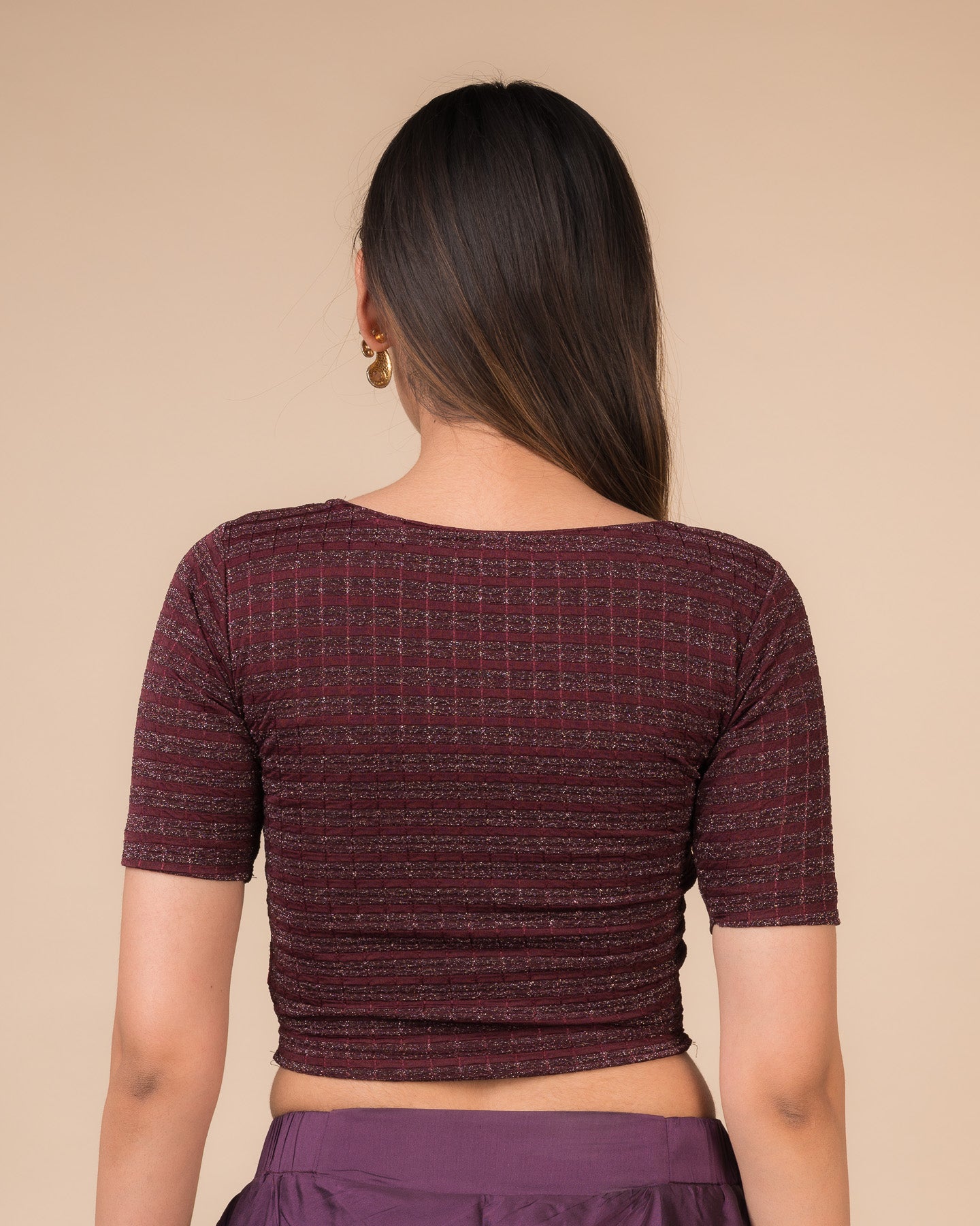 Rear view showcasing the back design of the metallic stripe blouse