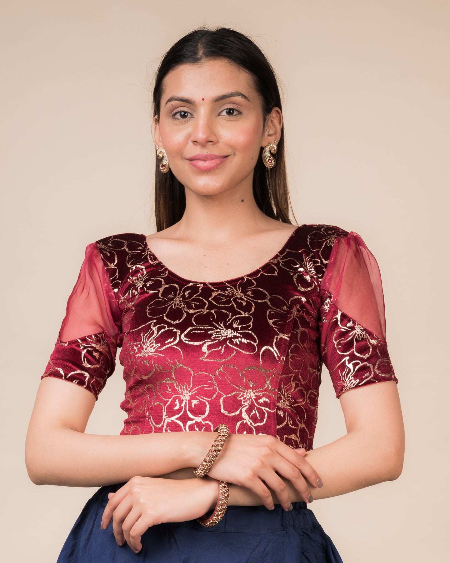 Model wearing a velvet stretchable blouse with floral-sequin embellishments, puff elbow sleeves, and round neckline