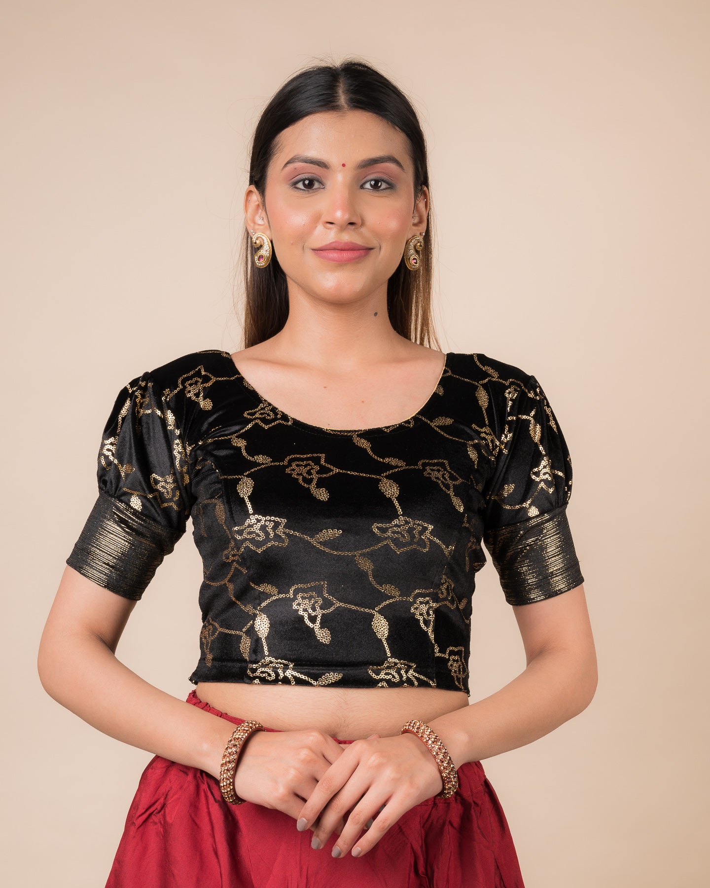 Model wearing a velvet blouse with metallic sequin foil, elbow puff sleeves, and round neckline