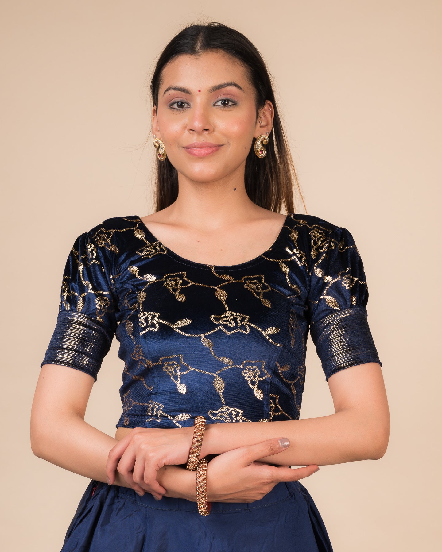 Model wearing a velvet blouse with metallic sequin foil, elbow puff sleeves, and round neckline