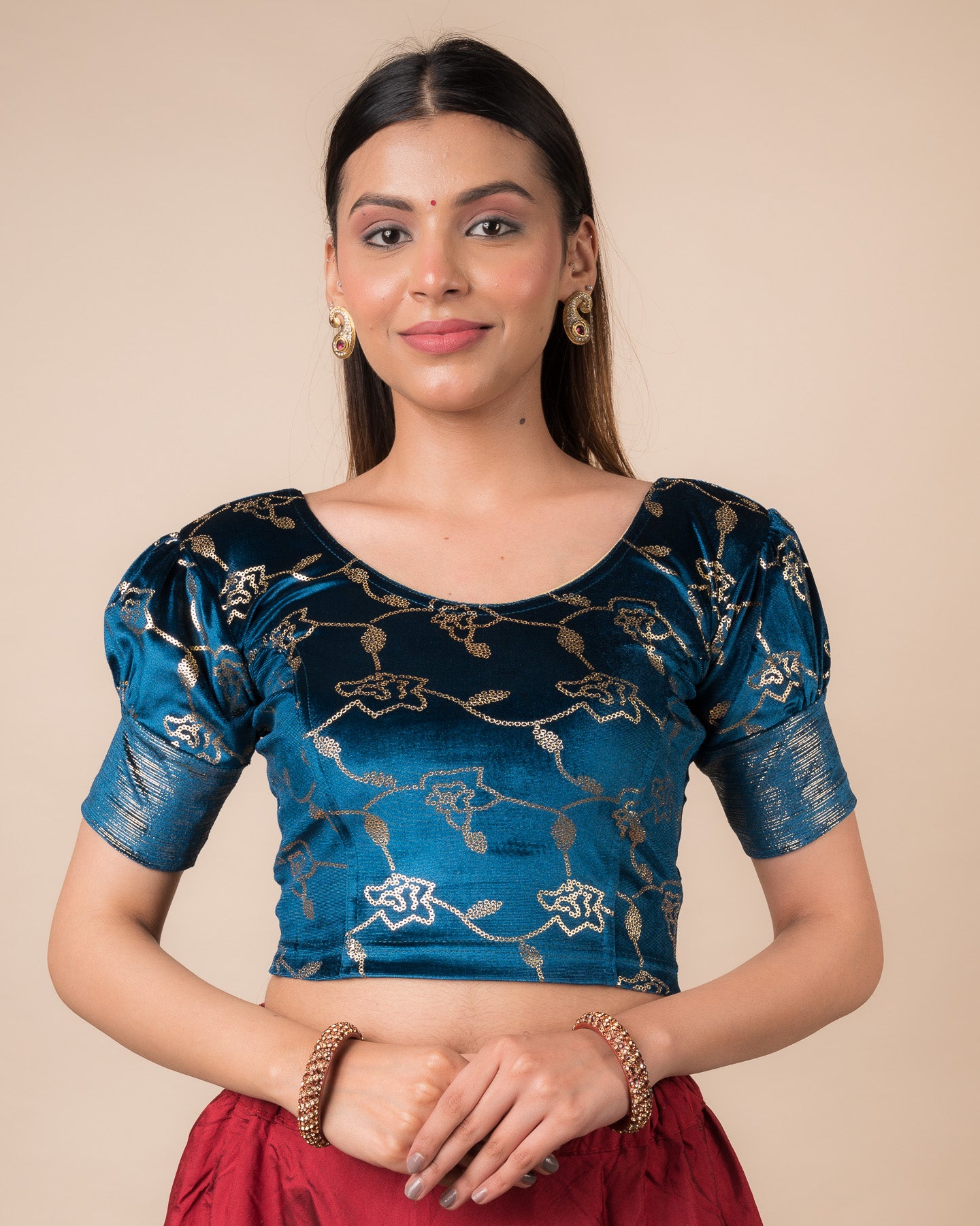 Model wearing a velvet blouse with metallic sequin foil, elbow puff sleeves, and round neckline